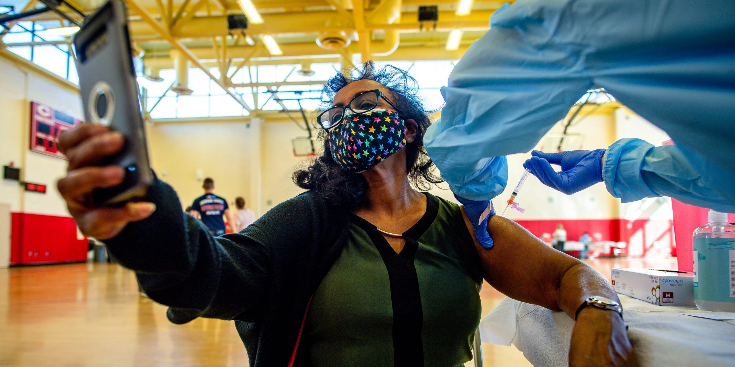 A woman taking a vaccine selfie.