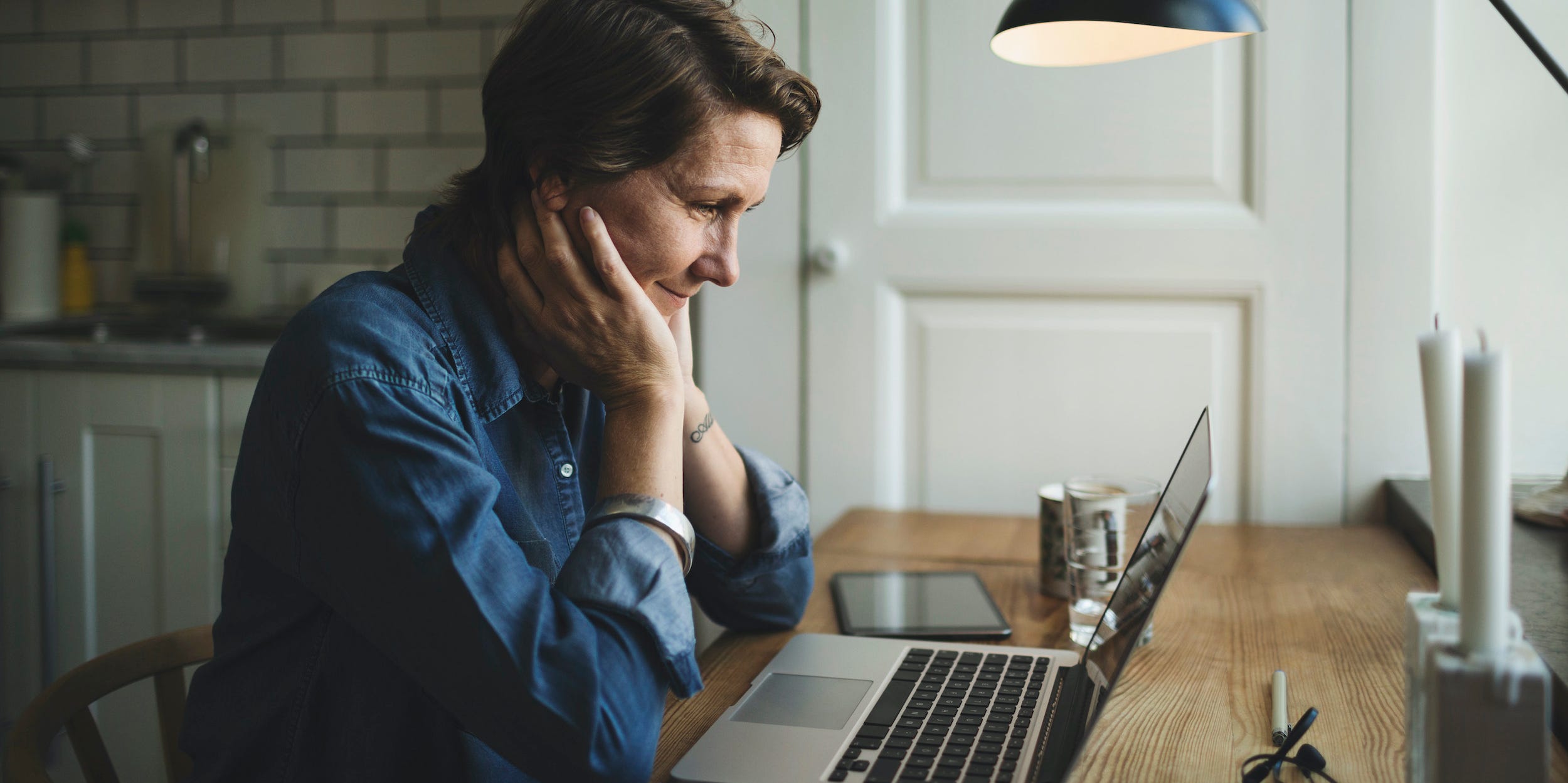 woman looking at laptop computer screen at home