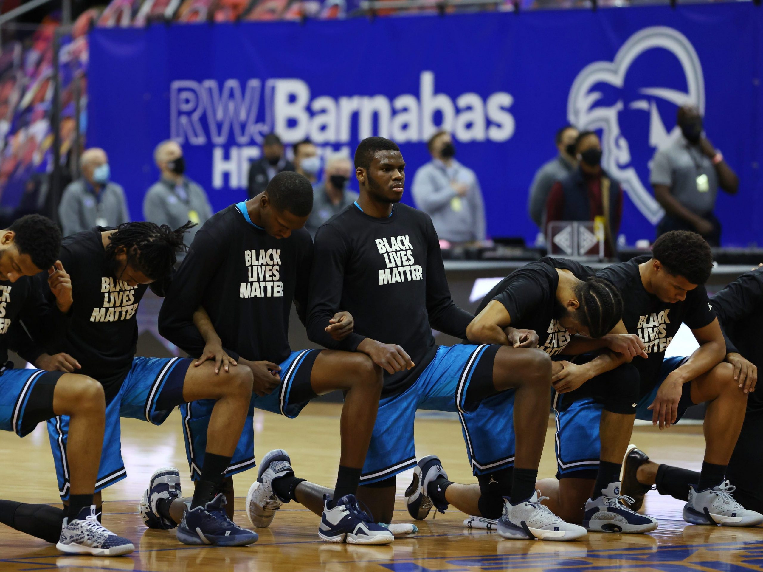 The Georgetown Hoyas kneel during the national anthem before a college basketball game against the Seton Hall Pirates at Prudential Center on December 23, 2020 in Newark, New Jersey. Seton Hall defeated Georgetown 78-67.