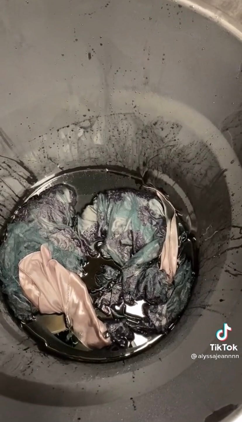 Alyssa Hevern's wedding dress in a tub of dye.