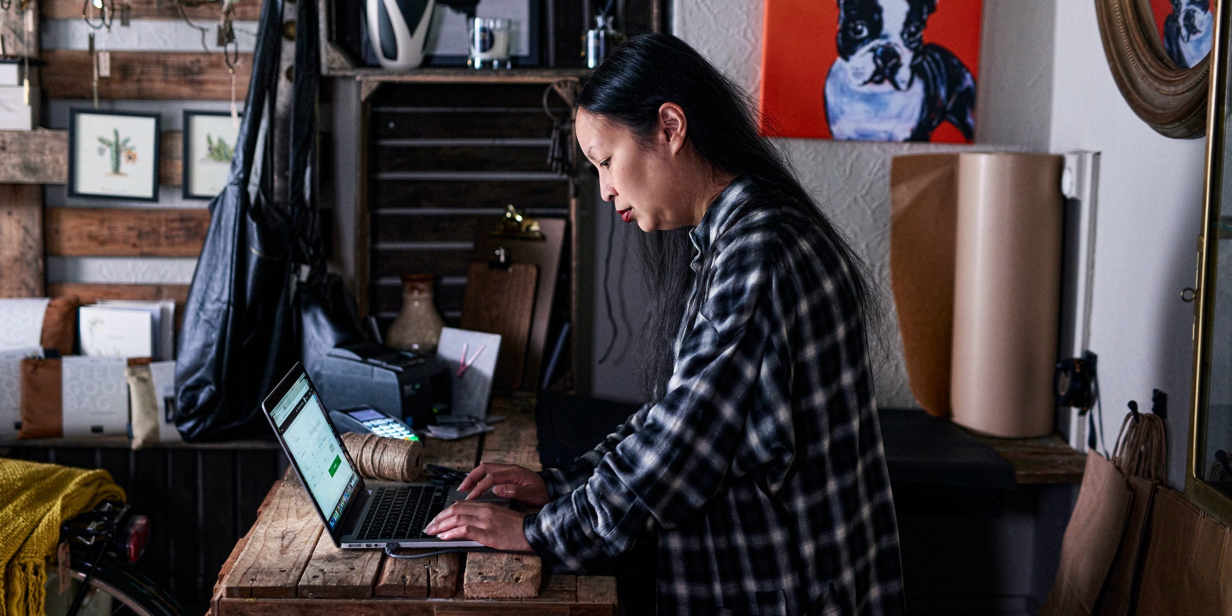 business owner using laptop in store