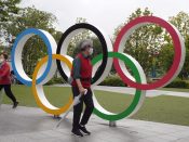 Bezoekers lopen langs de Olympische ringen bij het hoofdkantoor van het Japanse Olympische Comité in Tokio.
