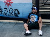 Een man zit voor het Argentijnse parlementsgebouw, waar binnen wordt gedebatteerd over de rijkentaks.