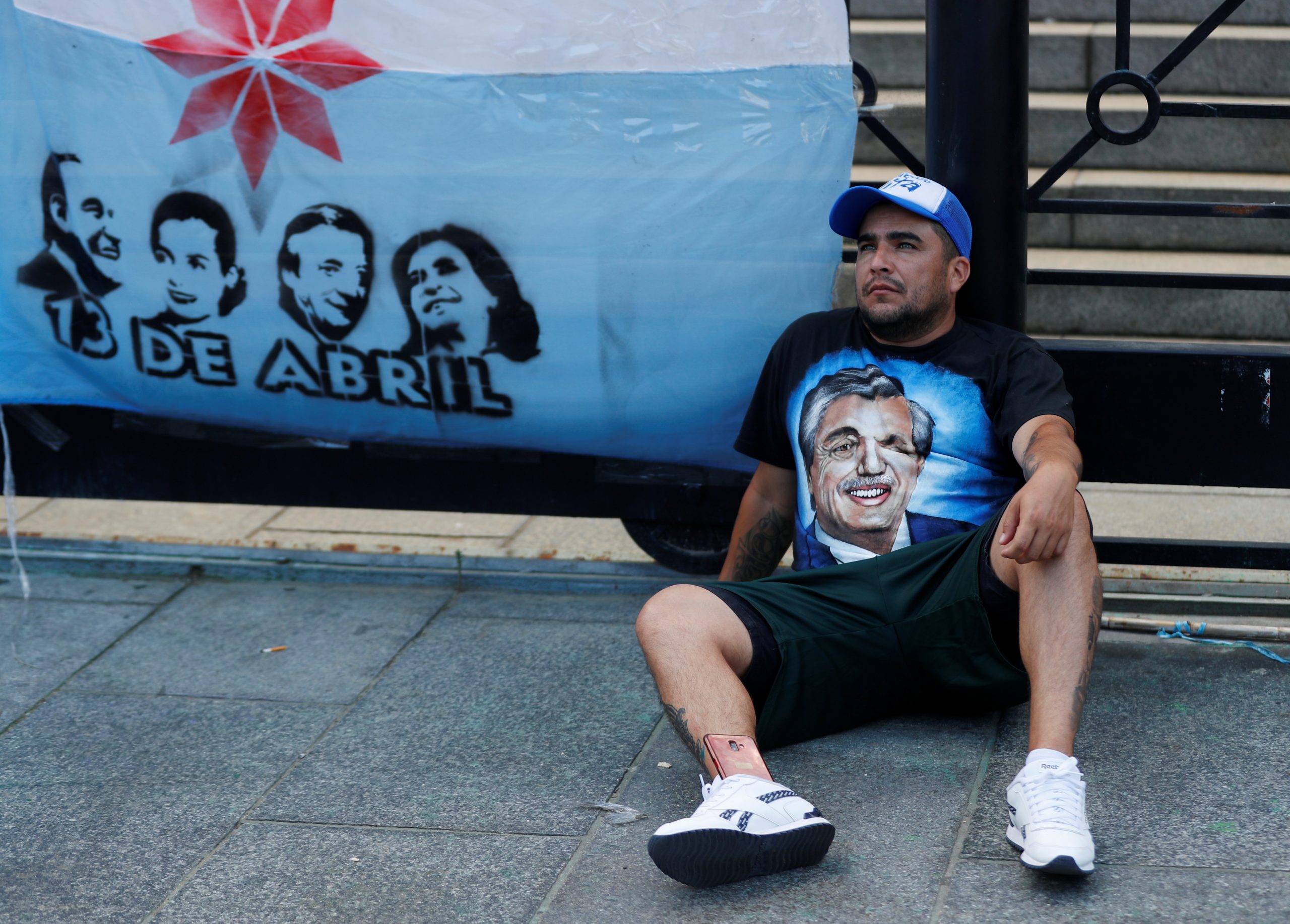 Een man zit voor het Argentijnse parlementsgebouw, waar binnen wordt gedebatteerd over de rijkentaks.