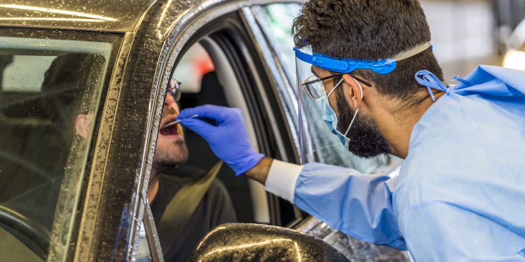 Een GGD-medewerker neemt een coronatest af bij de Amsterdamse RAI.