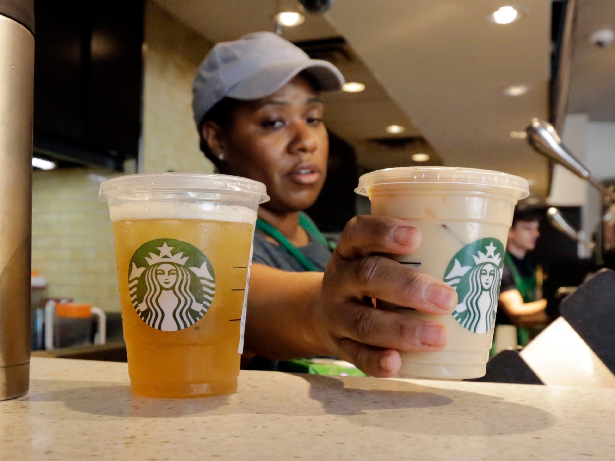 a Starbucks barista places ready drinks on a counter