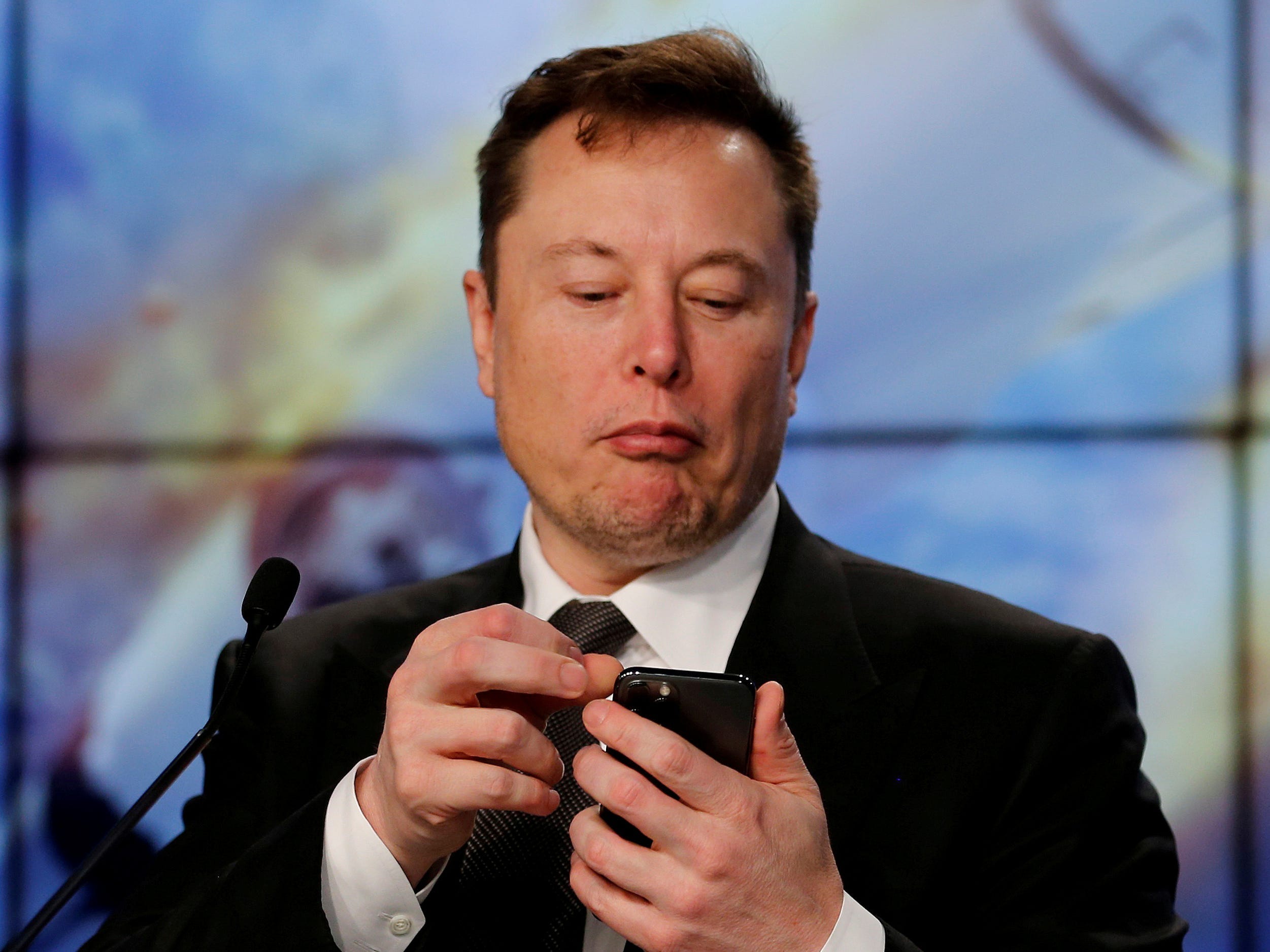 Elon Musk looking at his iPhone .JPG