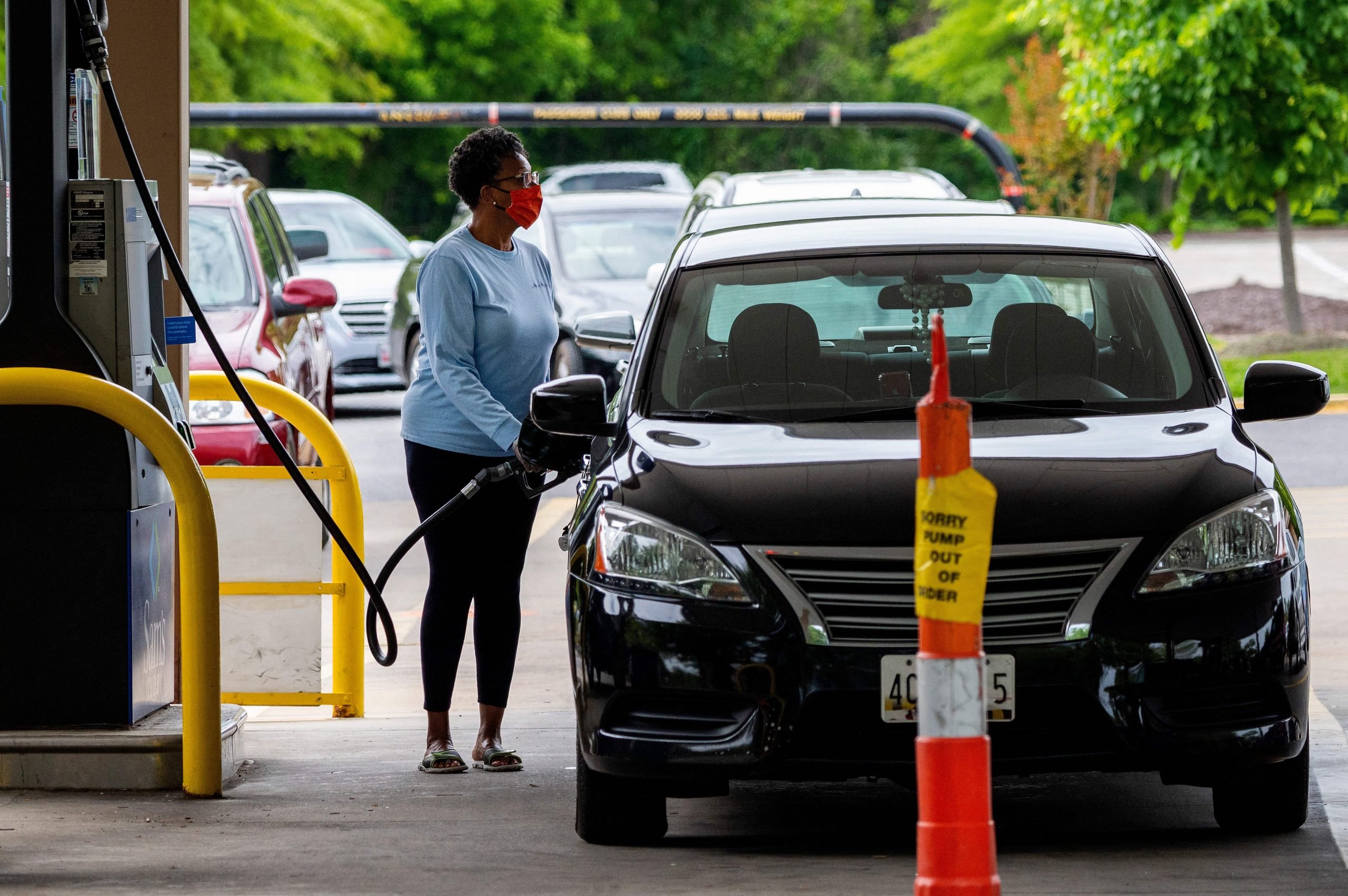 Woman uses gas pump during fuel shortage sparked by colonial pipeline attack