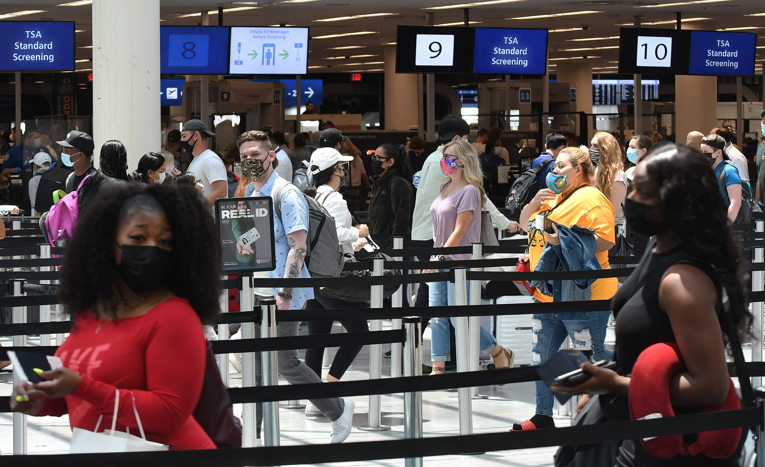 Airline passengers wait in line at an airport security checkpoint