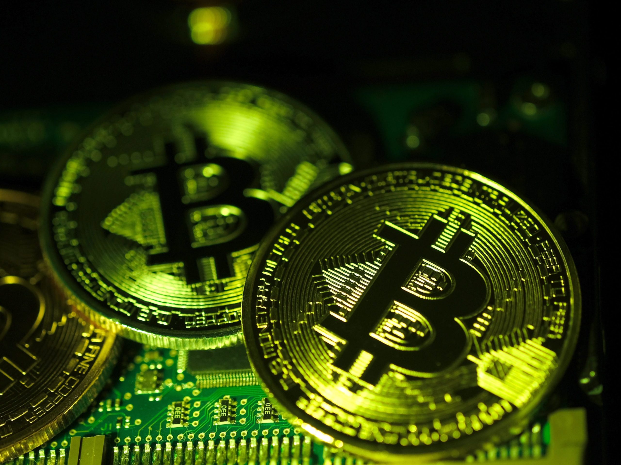 Visual representations of digital cryptocurrency Bitcoin (BTC) are arranged on a circuit board