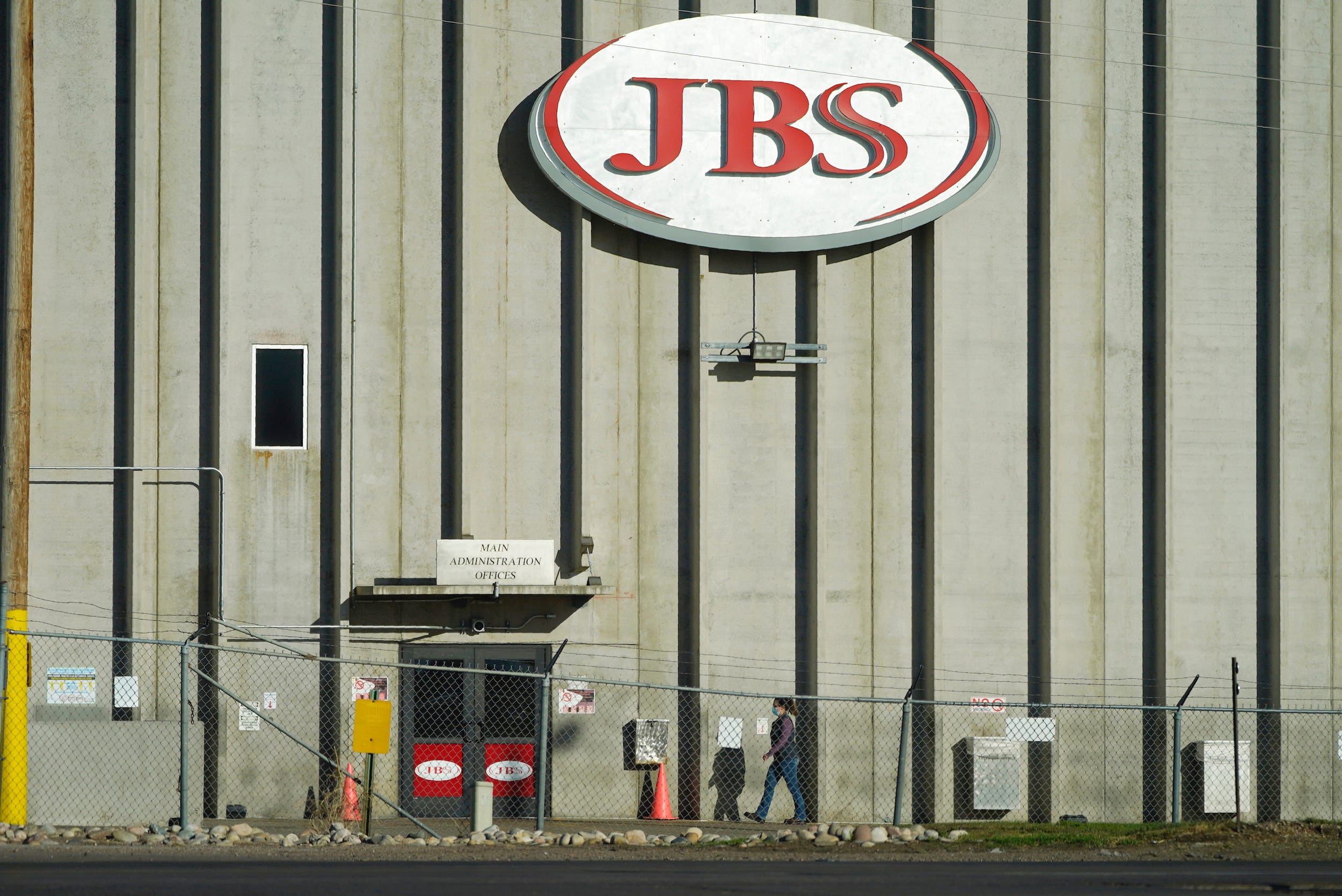 In this Oct. 12, 2020 file photo, a worker heads into the JBS meatpacking plant in Greeley, Colo