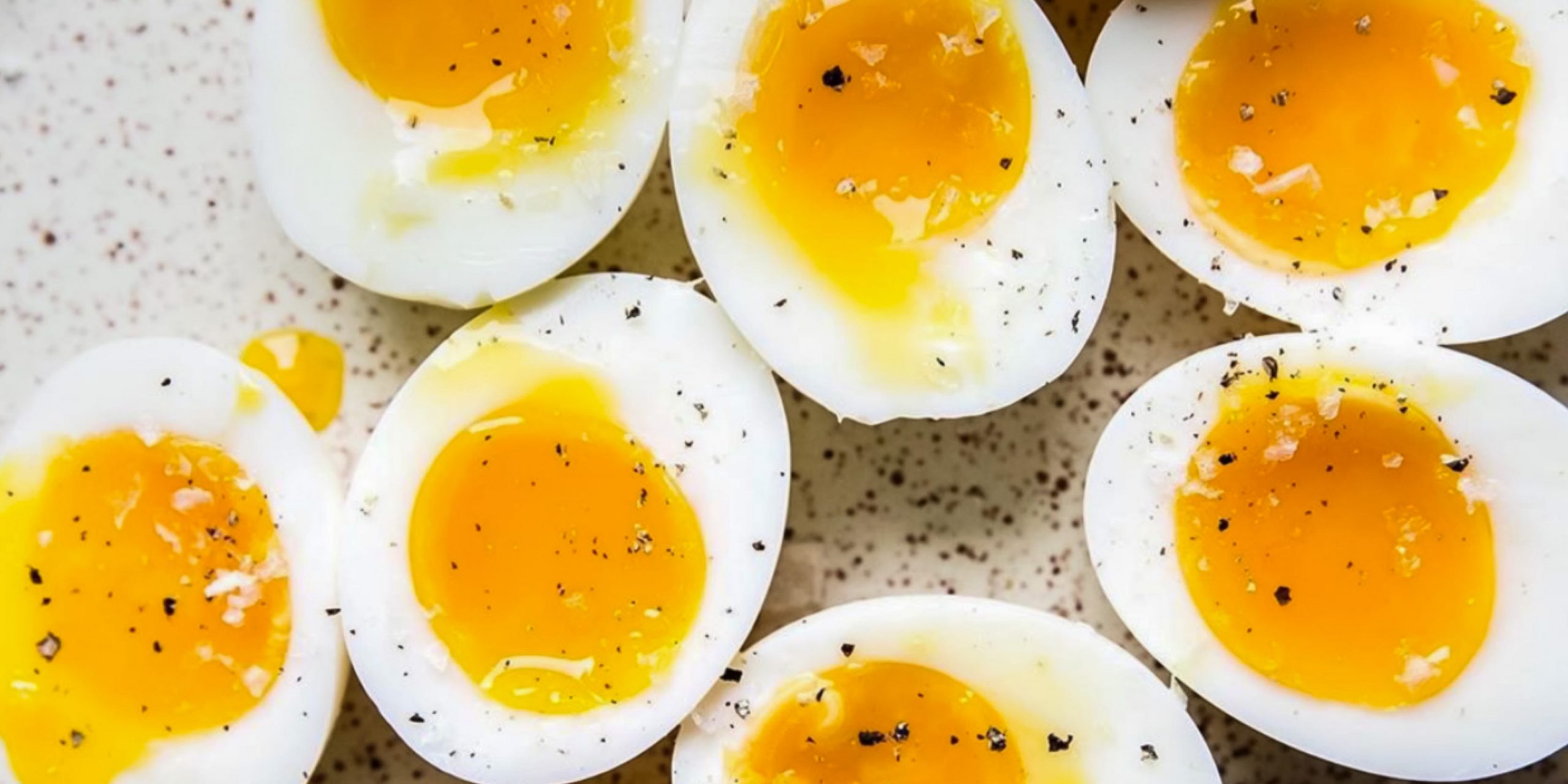 Several medium-boiled eggs sliced open with yolks oozing