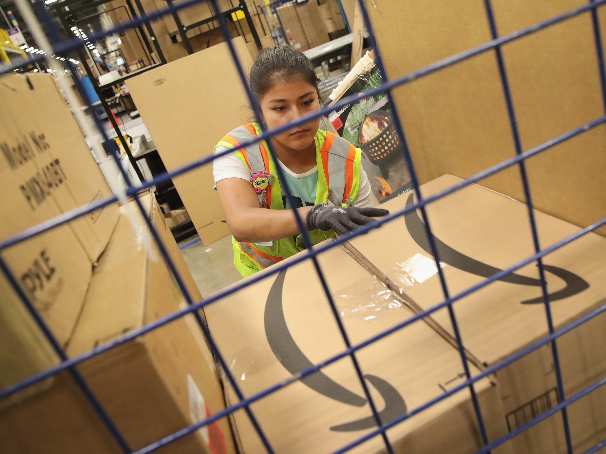 A worker packs a customer order at the 750,000-square-foot Amazon fulfillment center in Romeoville, Illinois.