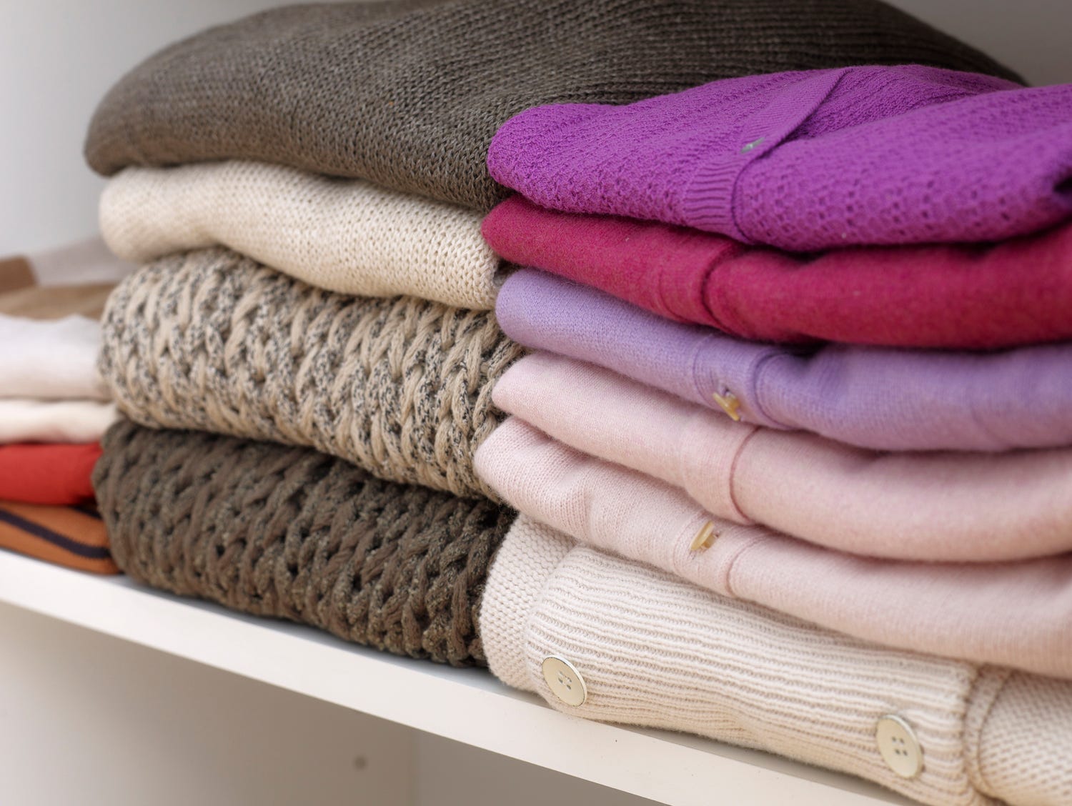 Sweaters folded and stacked on a shelf