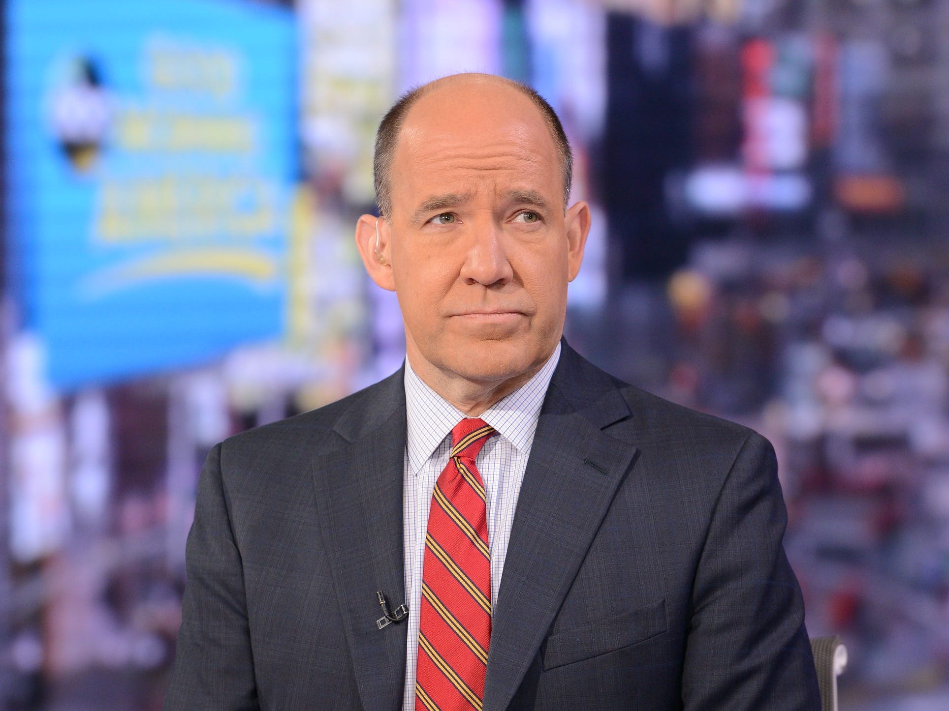 Matthew Dowd sits on set of Good Morning America in a black suit and red tie.