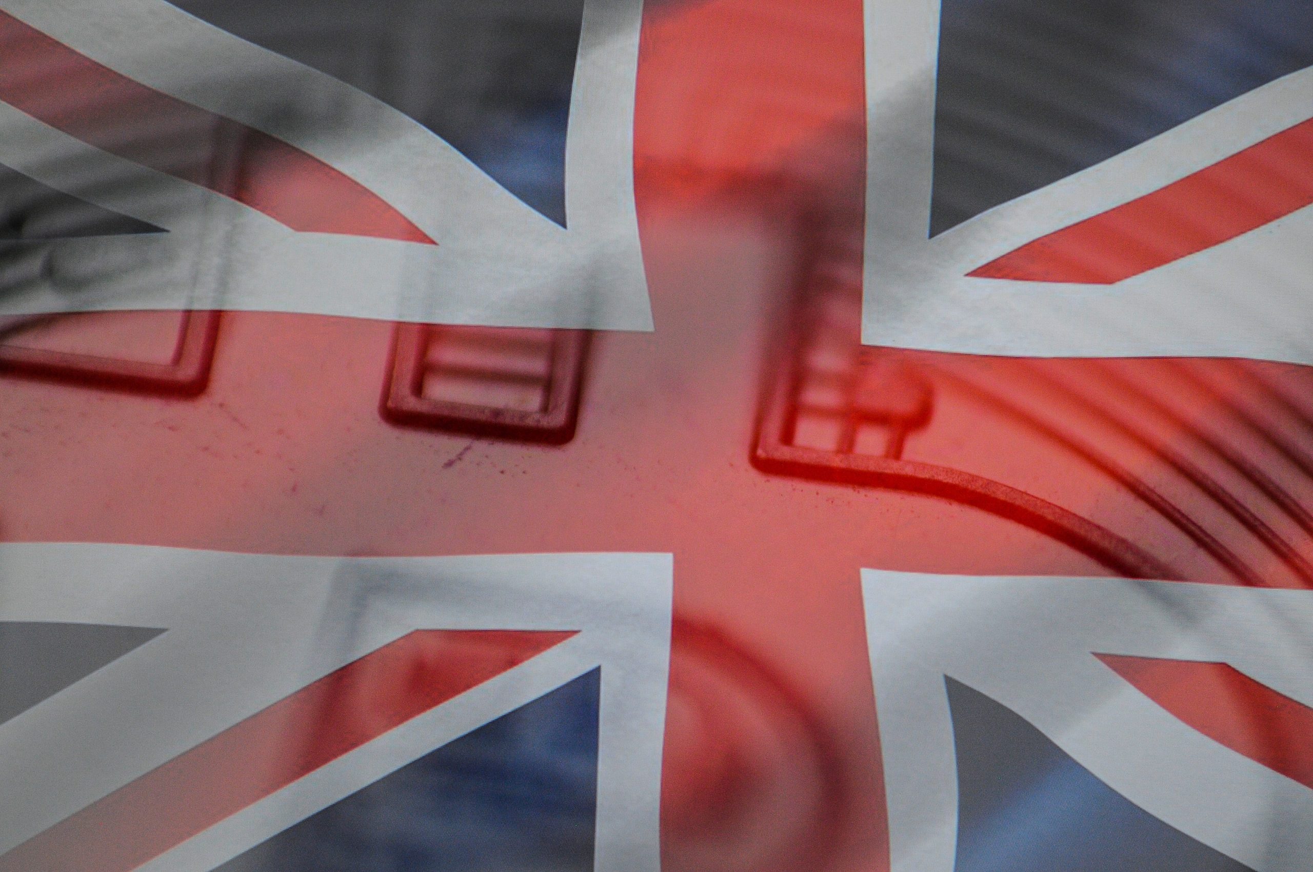 A close-up of a replica bitcion is seen with a British flag