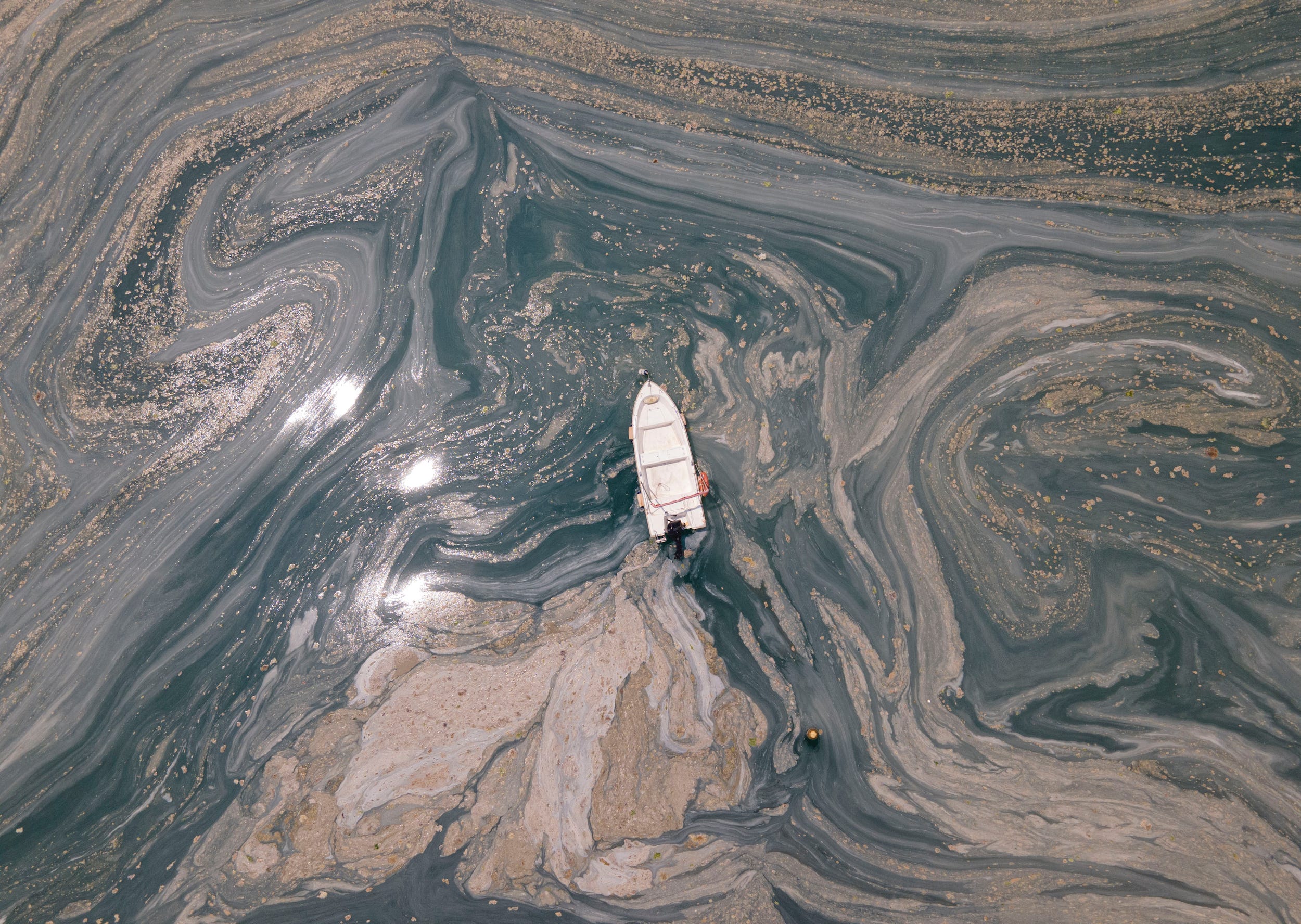 An aerial photo of the sea at the Caddebostan shore, in Asian side of Istanbul, Monday, June 7, 2021, with a huge mass of marine mucilage, a thick, slimy substance made up of compounds released by marine organisms, in Turkey's Marmara Sea.