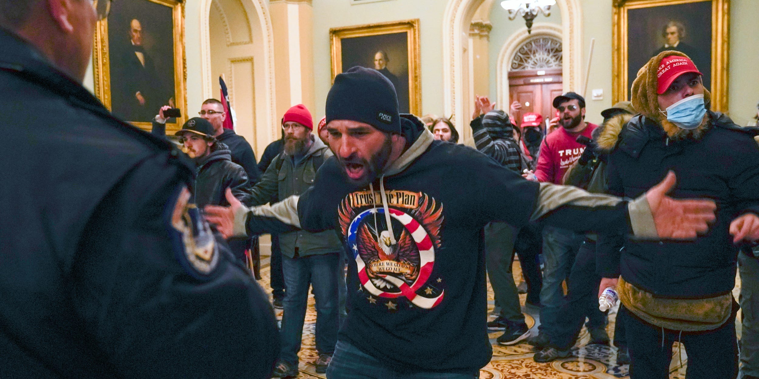 In this Jan. 6, 2021, file photo, Trump supporters gesture to U.S. Capitol Police in the hallway outside of the Senate chamber at the Capitol in Washington. Doug Jensen, an Iowa man at center, was jailed early Saturday, Jan. 9, 2021 on federal charges, including trespassing and disorderly conduct counts, for his alleged role in the Capitol riot.