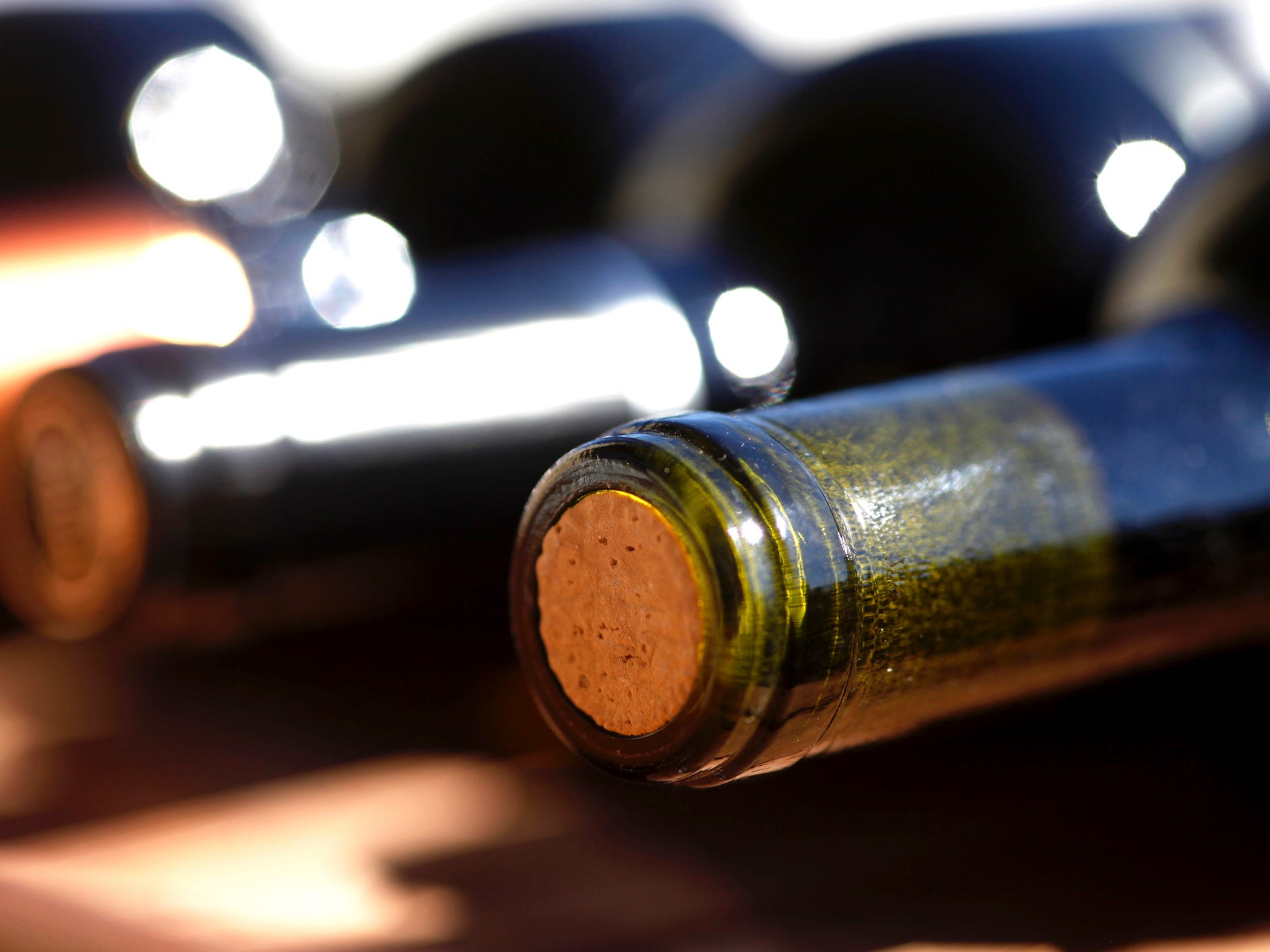 Wine bottles on their side with exposed corks