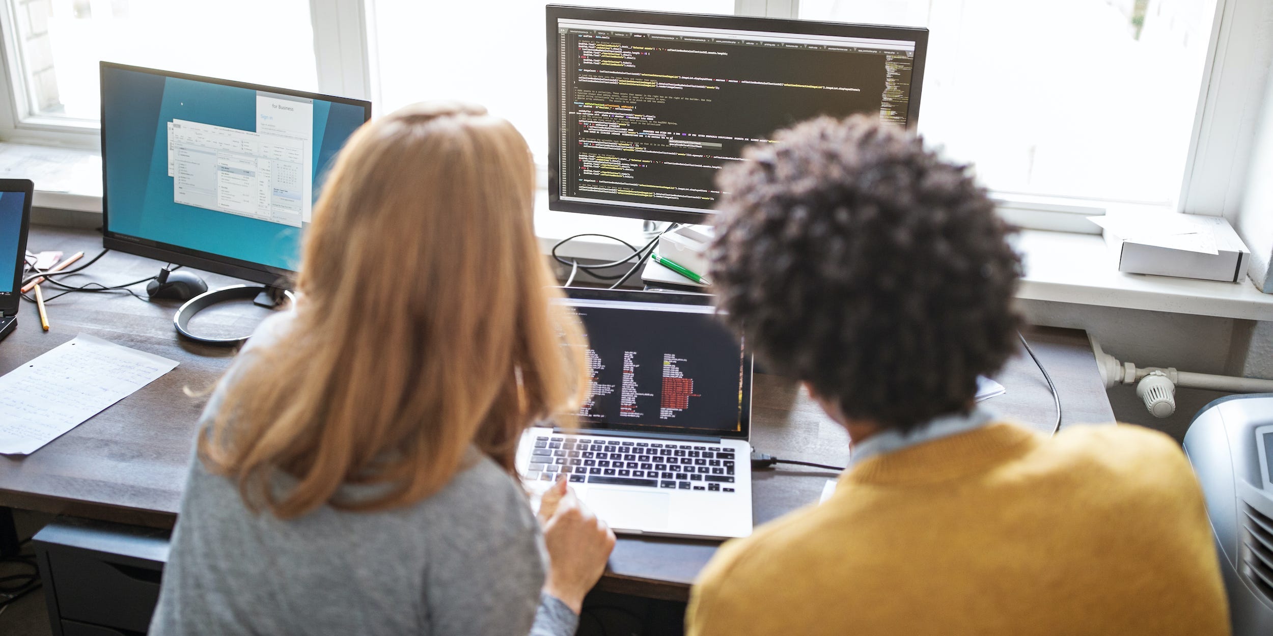 coworkers coding on computer together