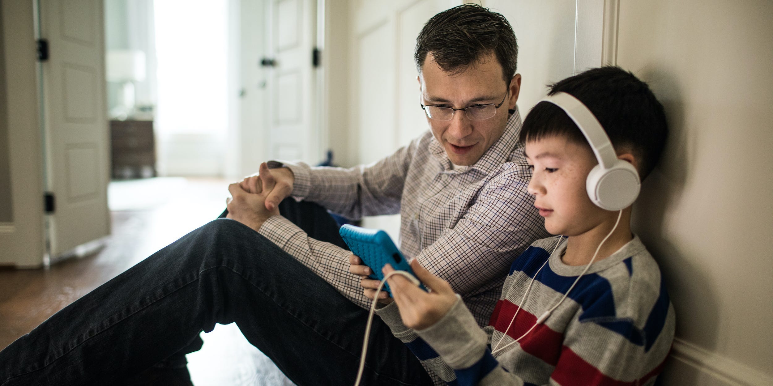 parent and child looking at tablet together