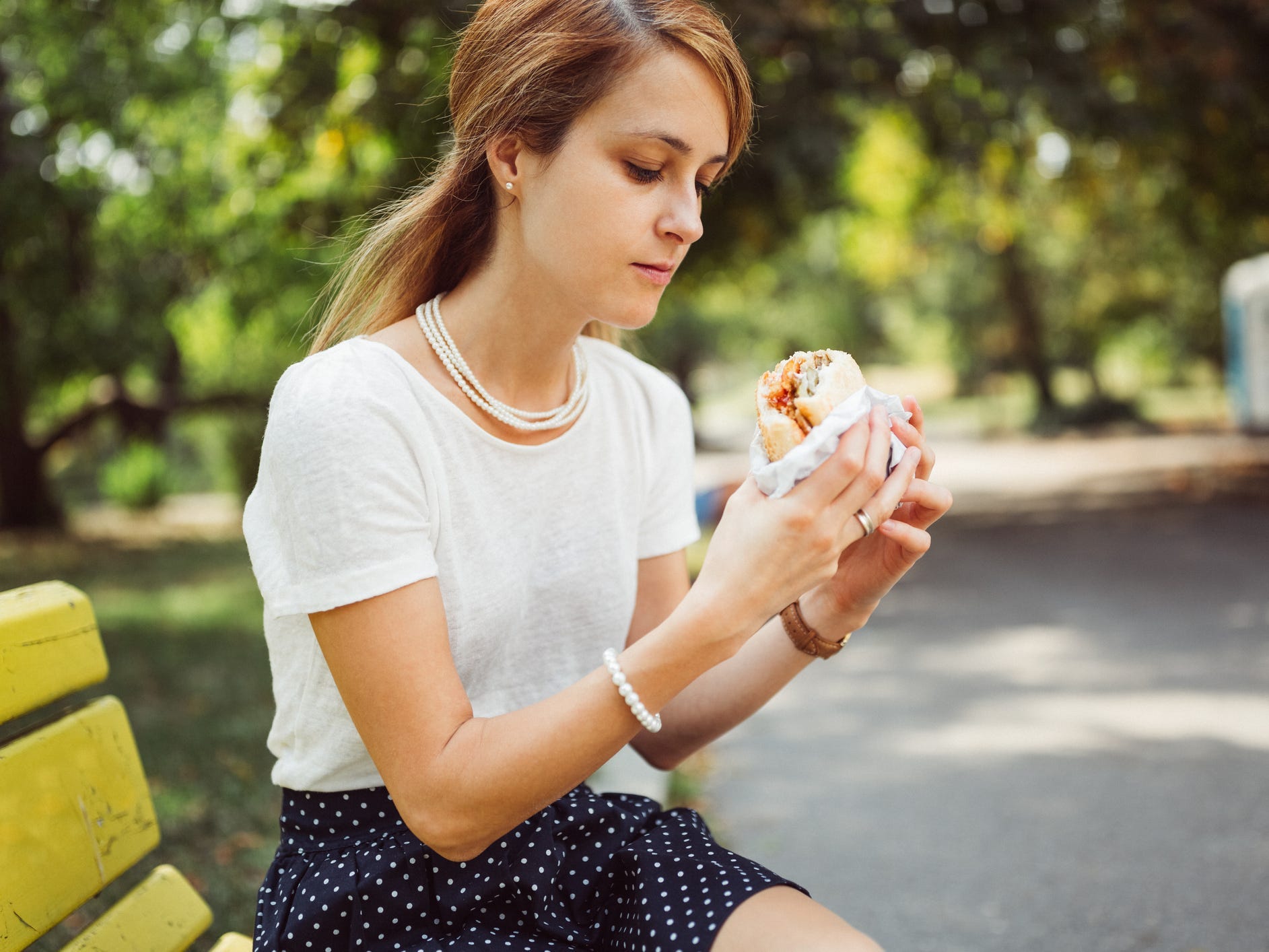 woman eating fast food burger stress office lunch