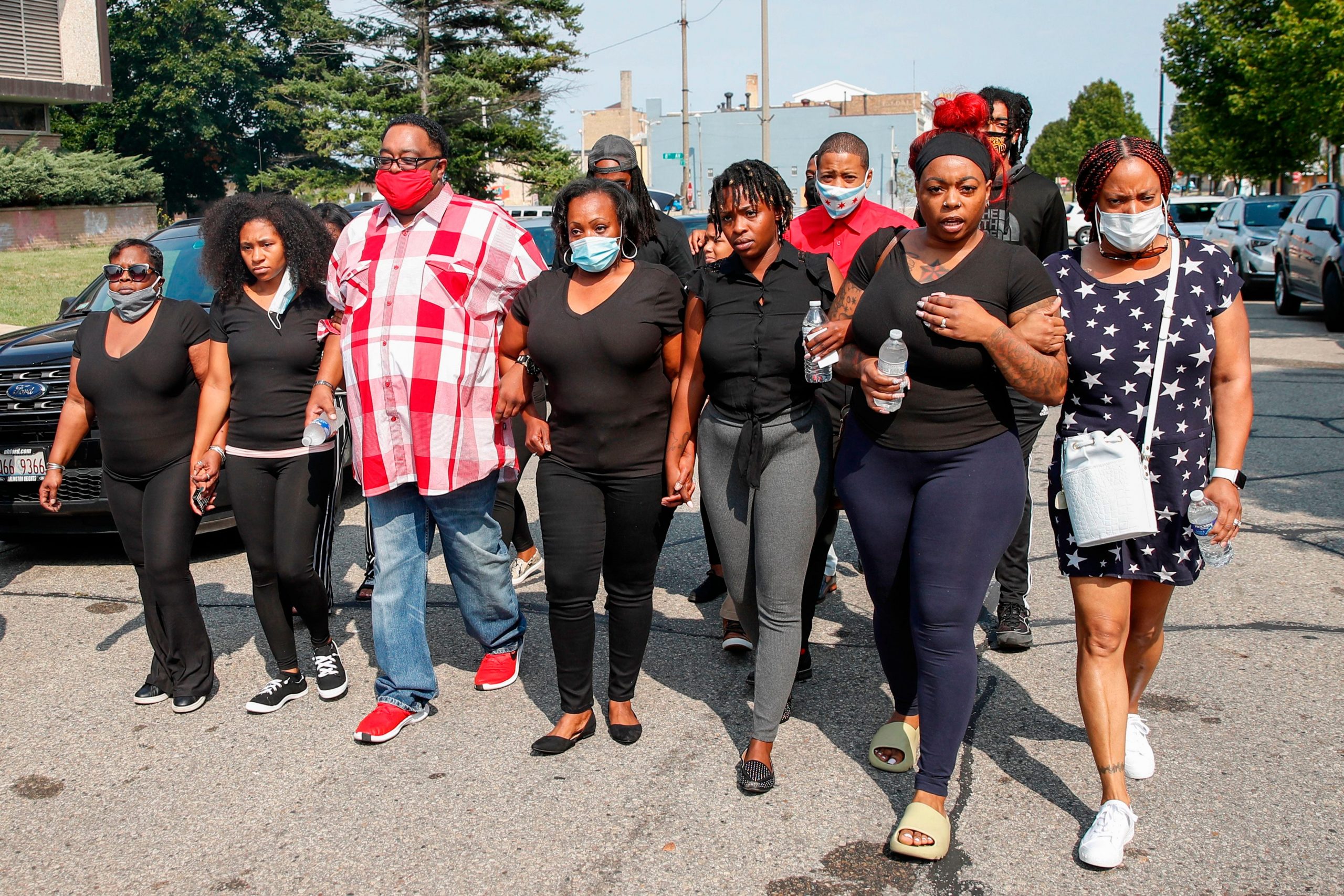 jacob blake's relatives march down the street linking arms