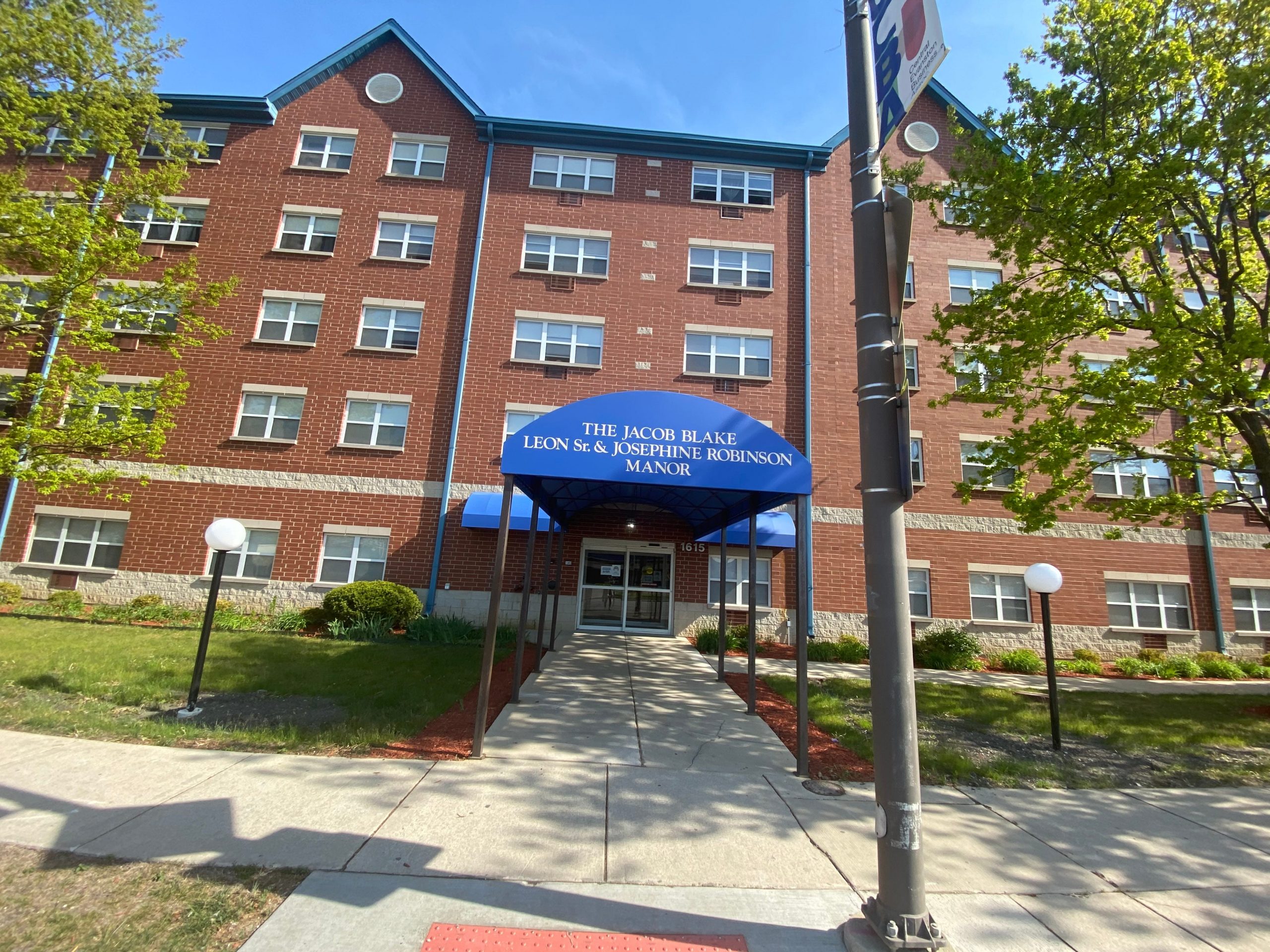 an apartment building with a bright blue sky and trees