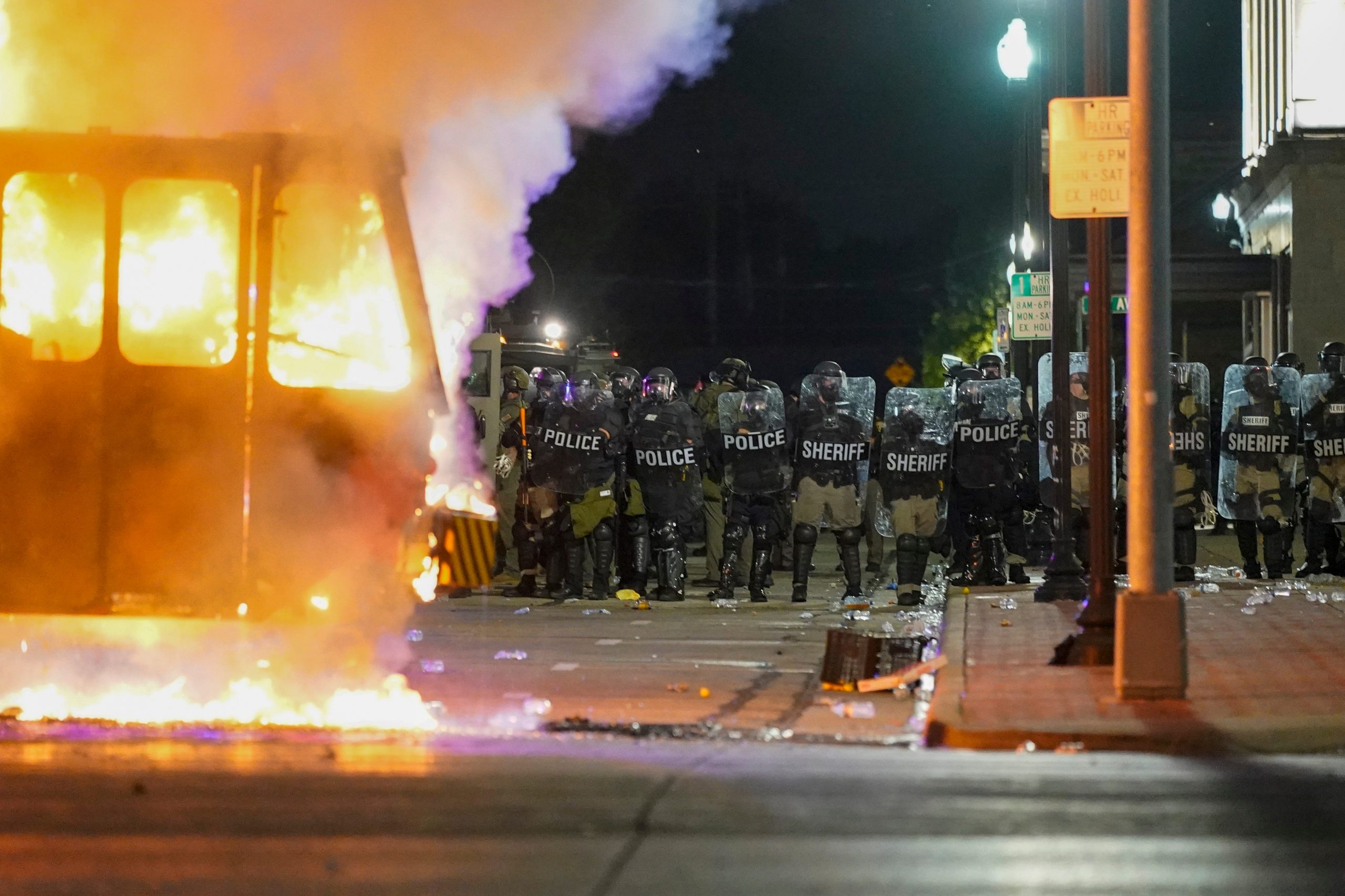 police line up behind a riot fire in kenosha