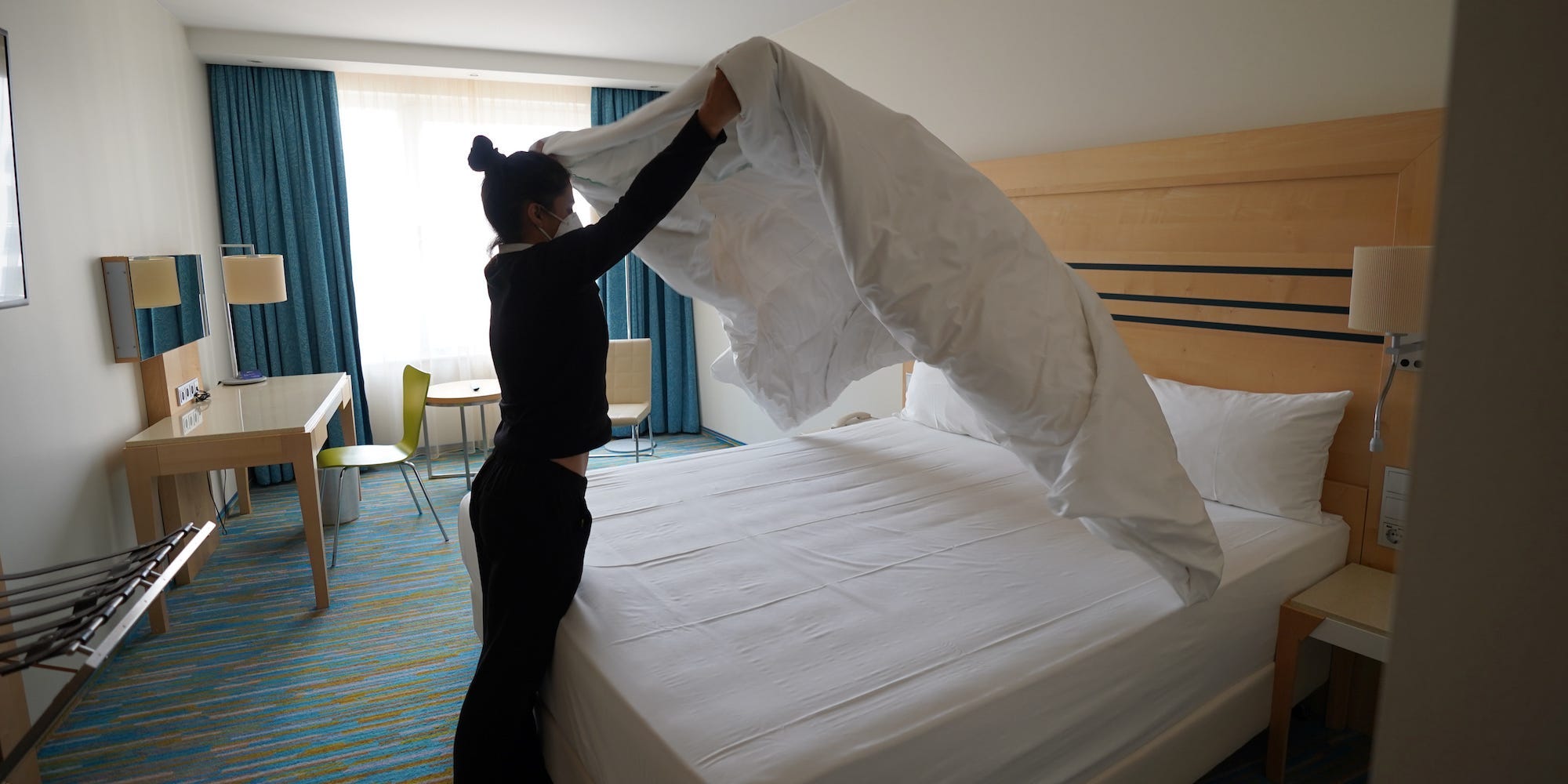 A woman makes a hotel bed