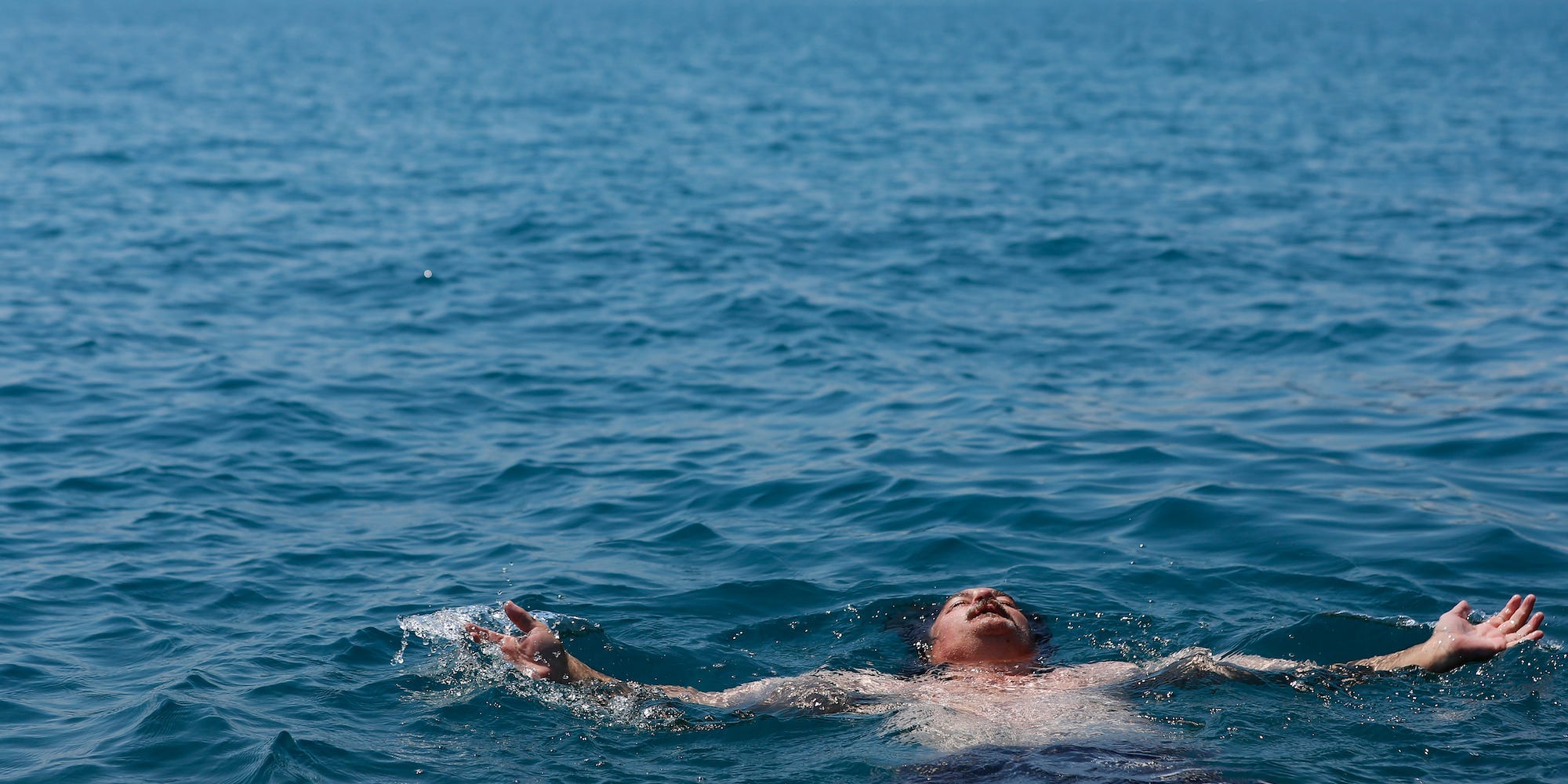 Dan O'Conor, the "Great Lake Jumper," closes his eyes while floating on the water after his 363rd consecutive daily plunge into Lake Michigan, Thursday, June 10, 2021, in Chicago's Montrose Point.