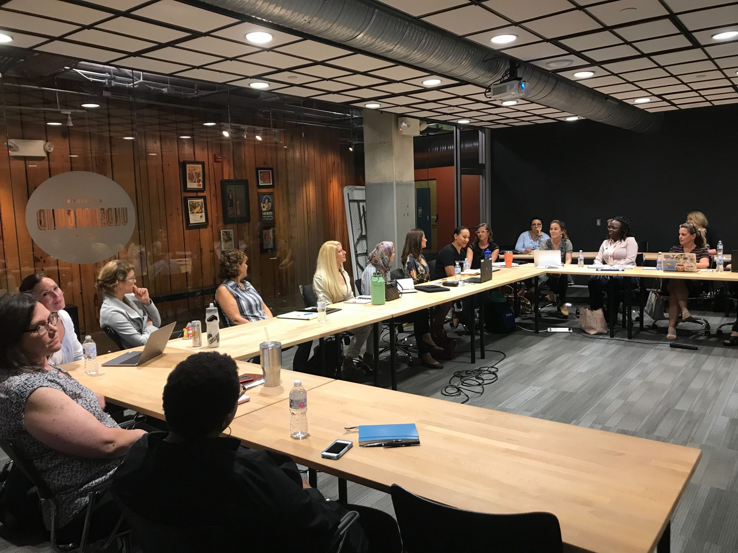 large group of people around table in board room