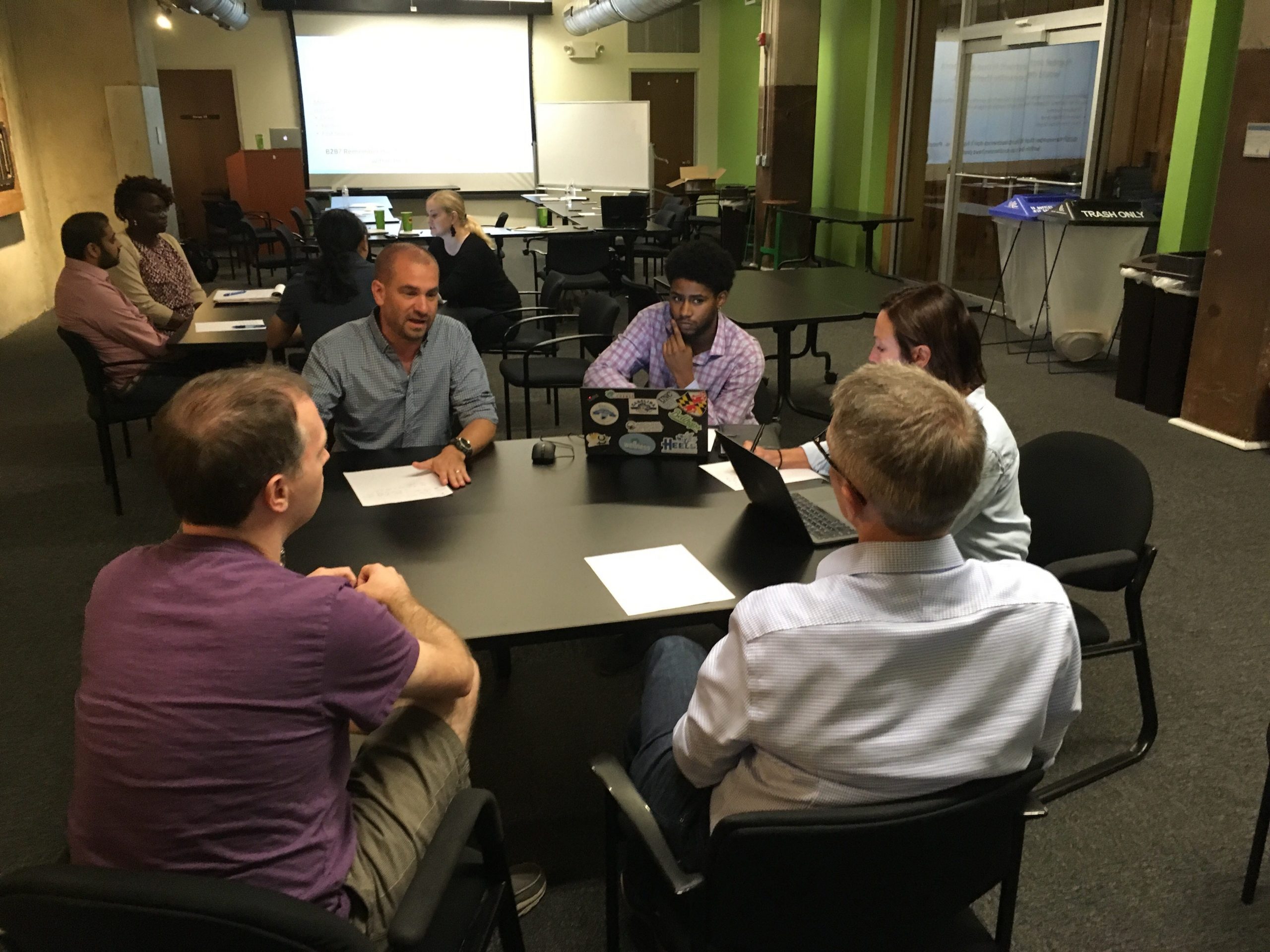 Group of men around a table with laptop