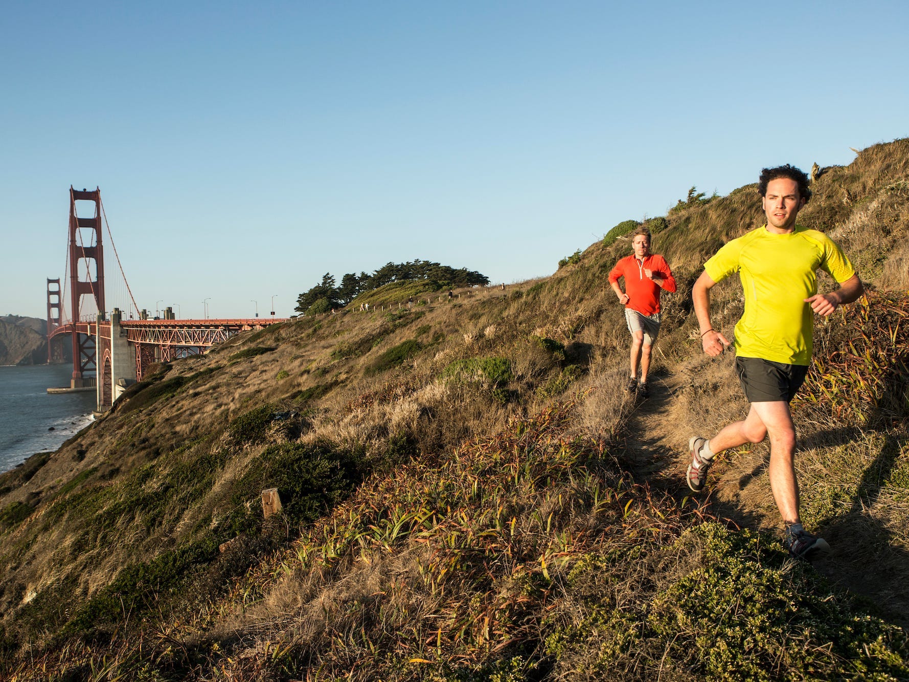 Two men running with the Golden Gate Bridge in the background.