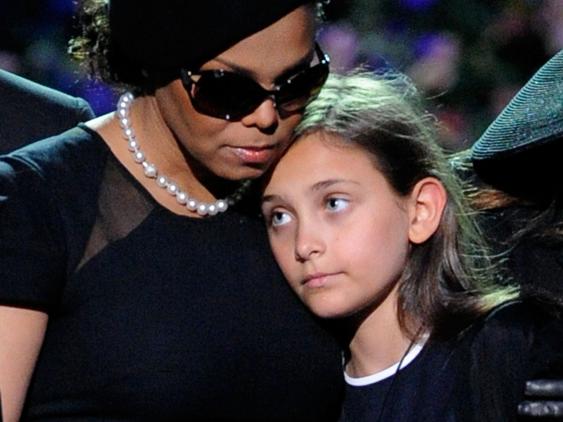 Paris Jackson leaning on Janet Jackson while in attendance at a memorial service for Michael Jackson in July 2009.