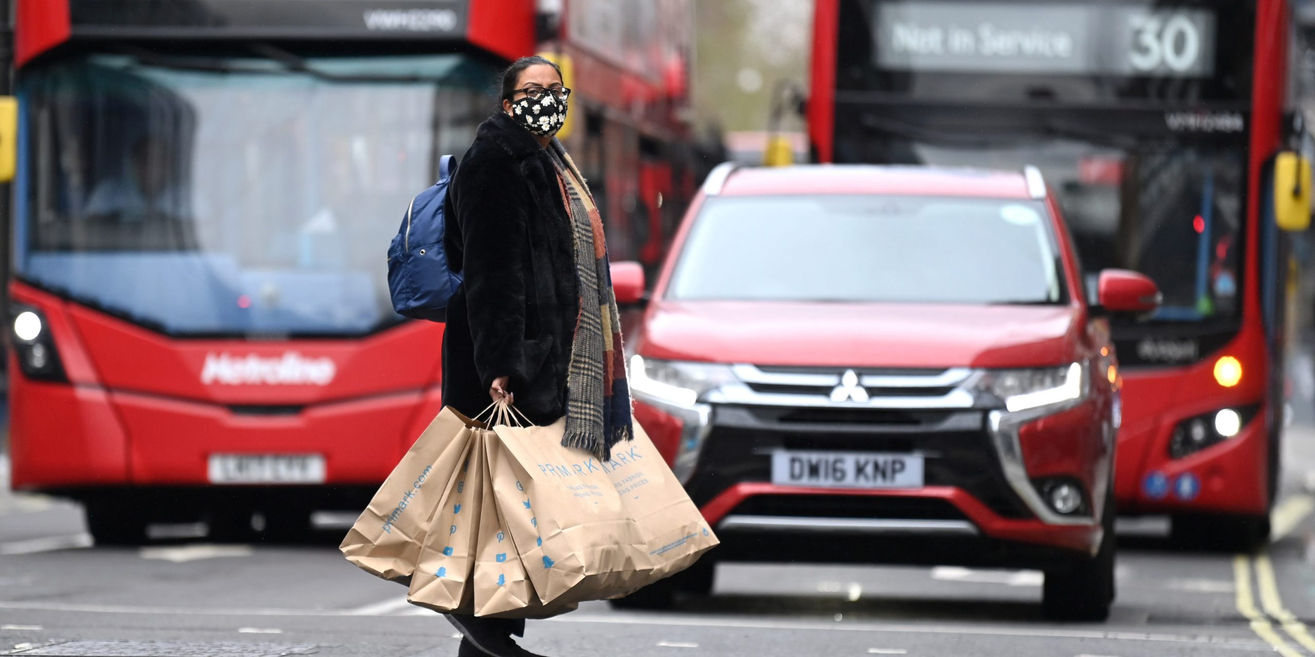 UK woman shopping shops red bus economy reopens London