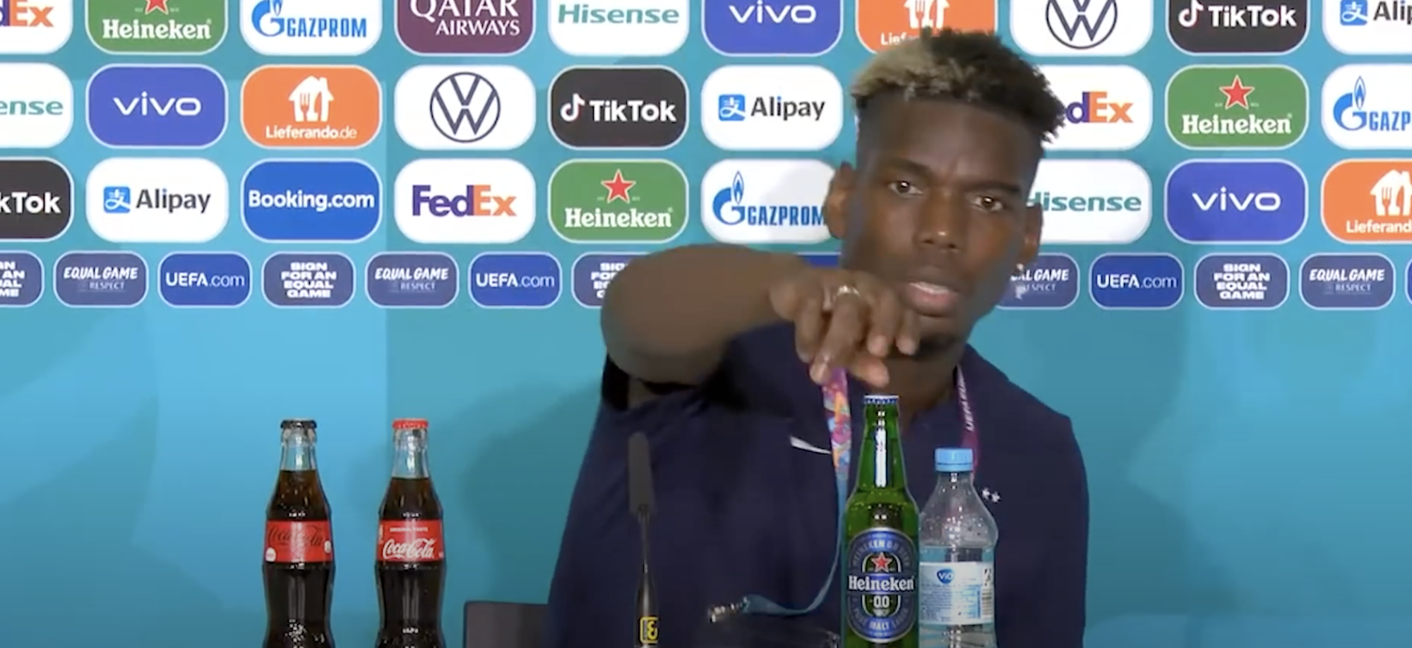 Paul Pogba removes a Heineken bottle from his table during a Euro 2020 press conference