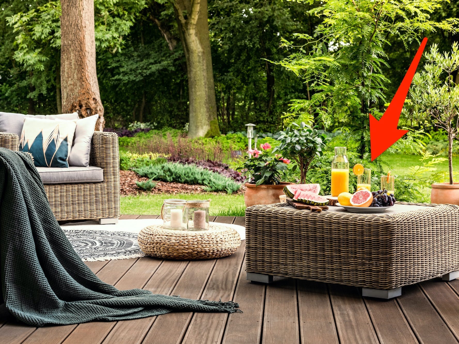 A patio with two chairs and an ottoman with juice on it. An arrow points to the ottoman.