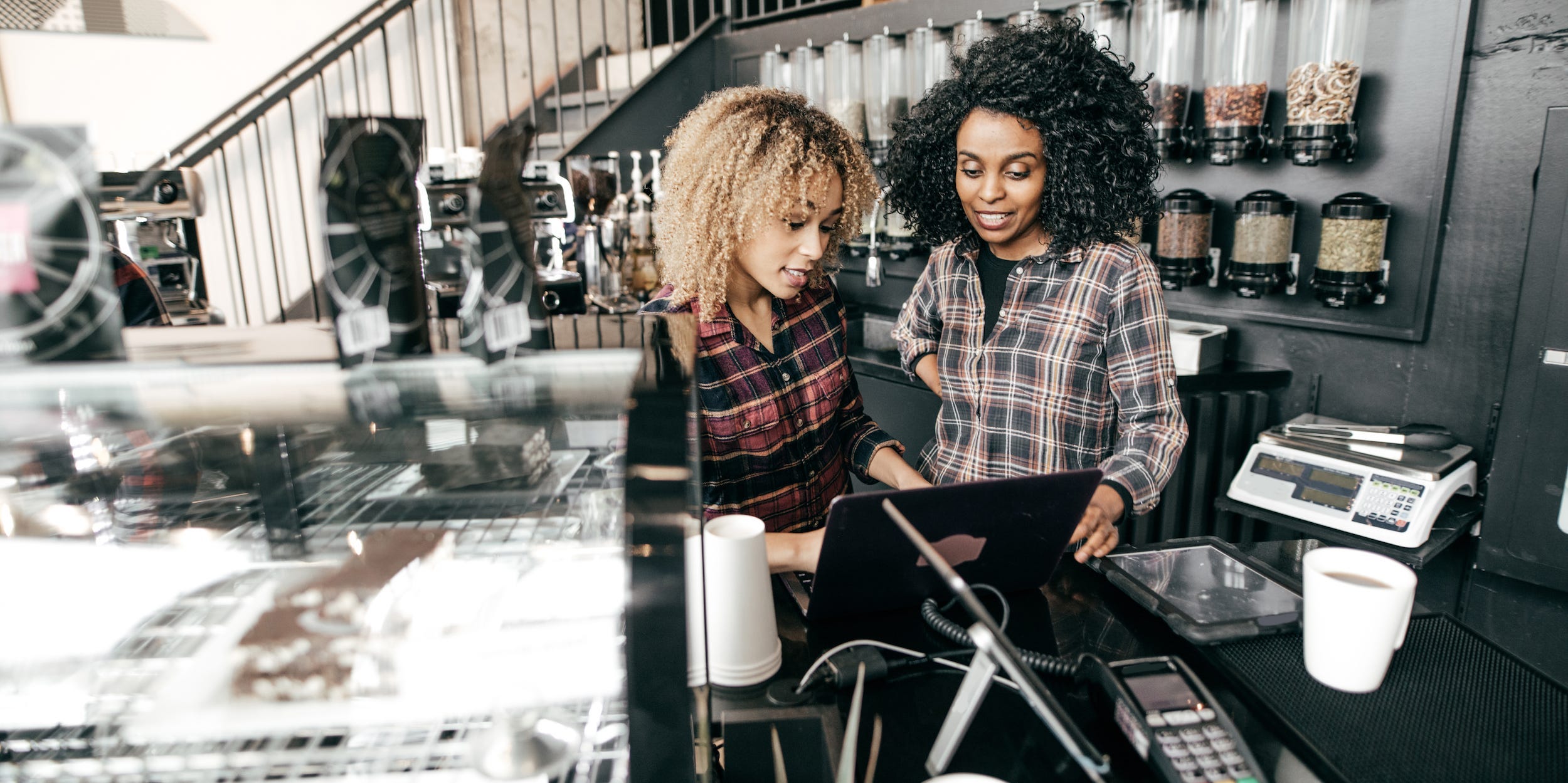 business partners in coffee shop looking at laptop together