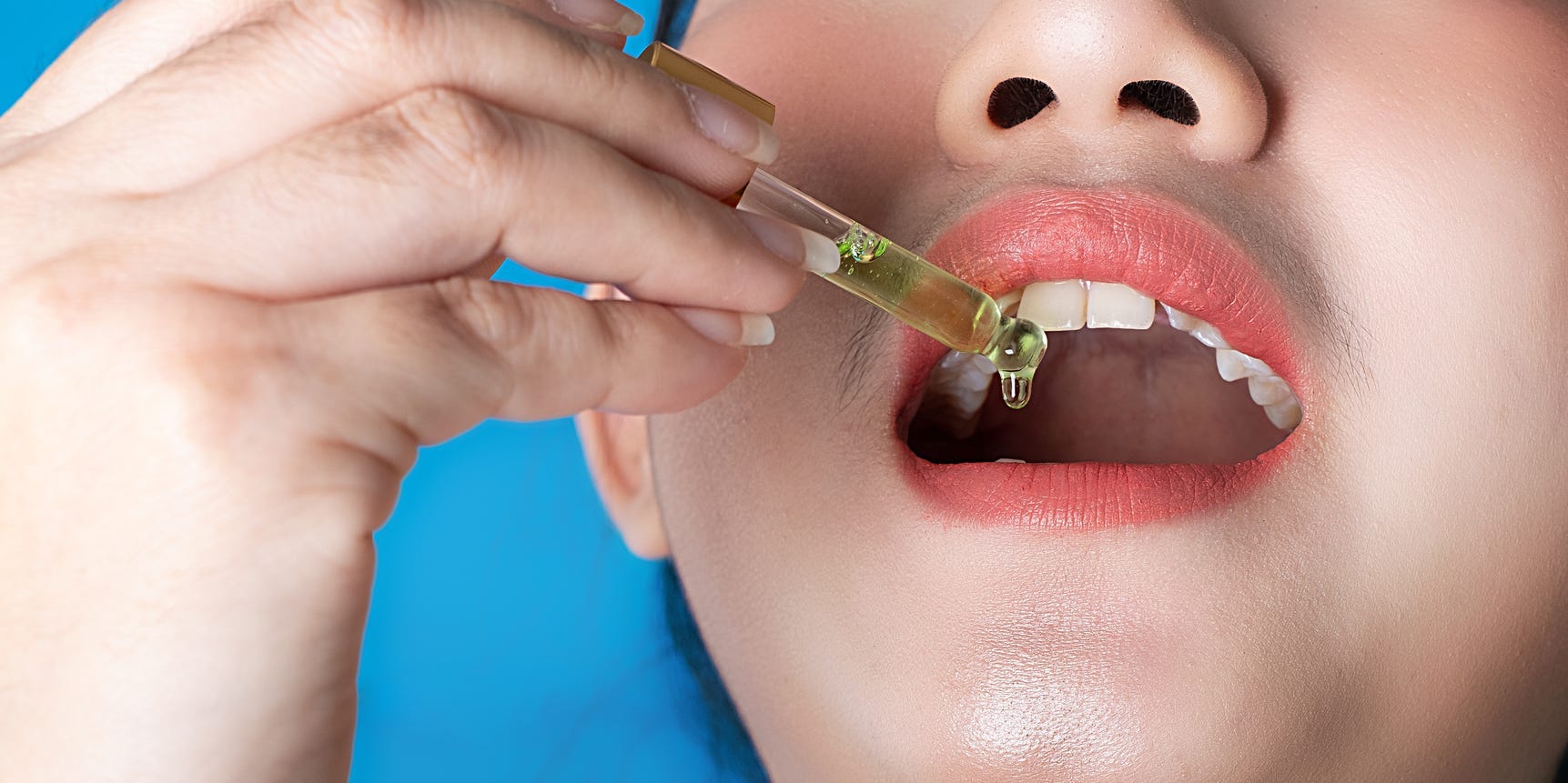 woman placing cannabis tincture under tonguw