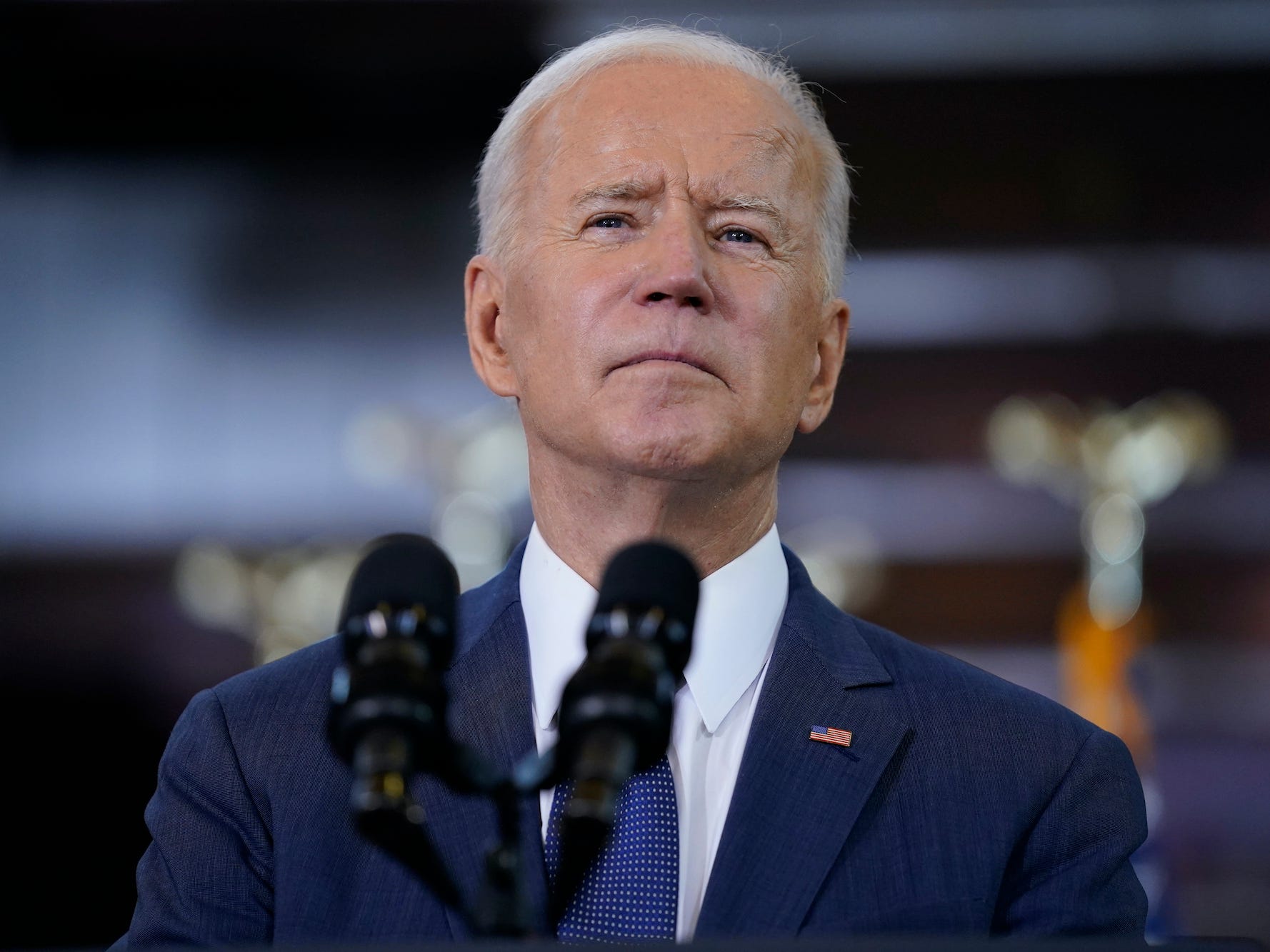 President Joe Biden stands at a microphone