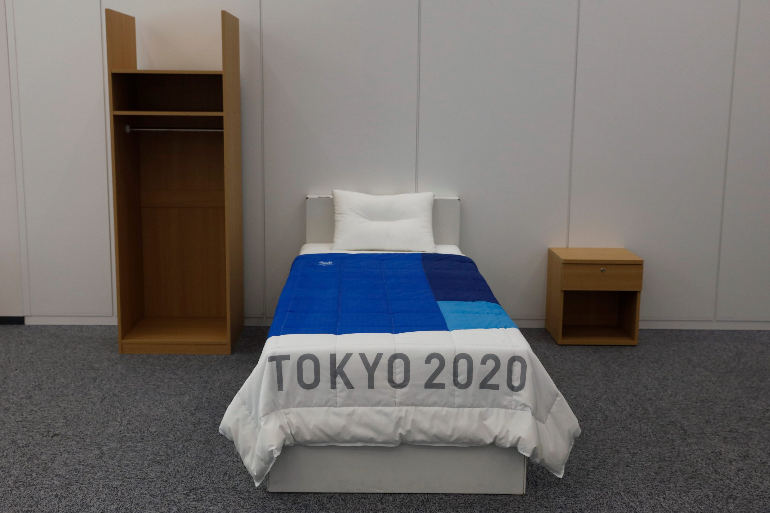 A single bed with a blanket reading Tokyo 2020 in Japan