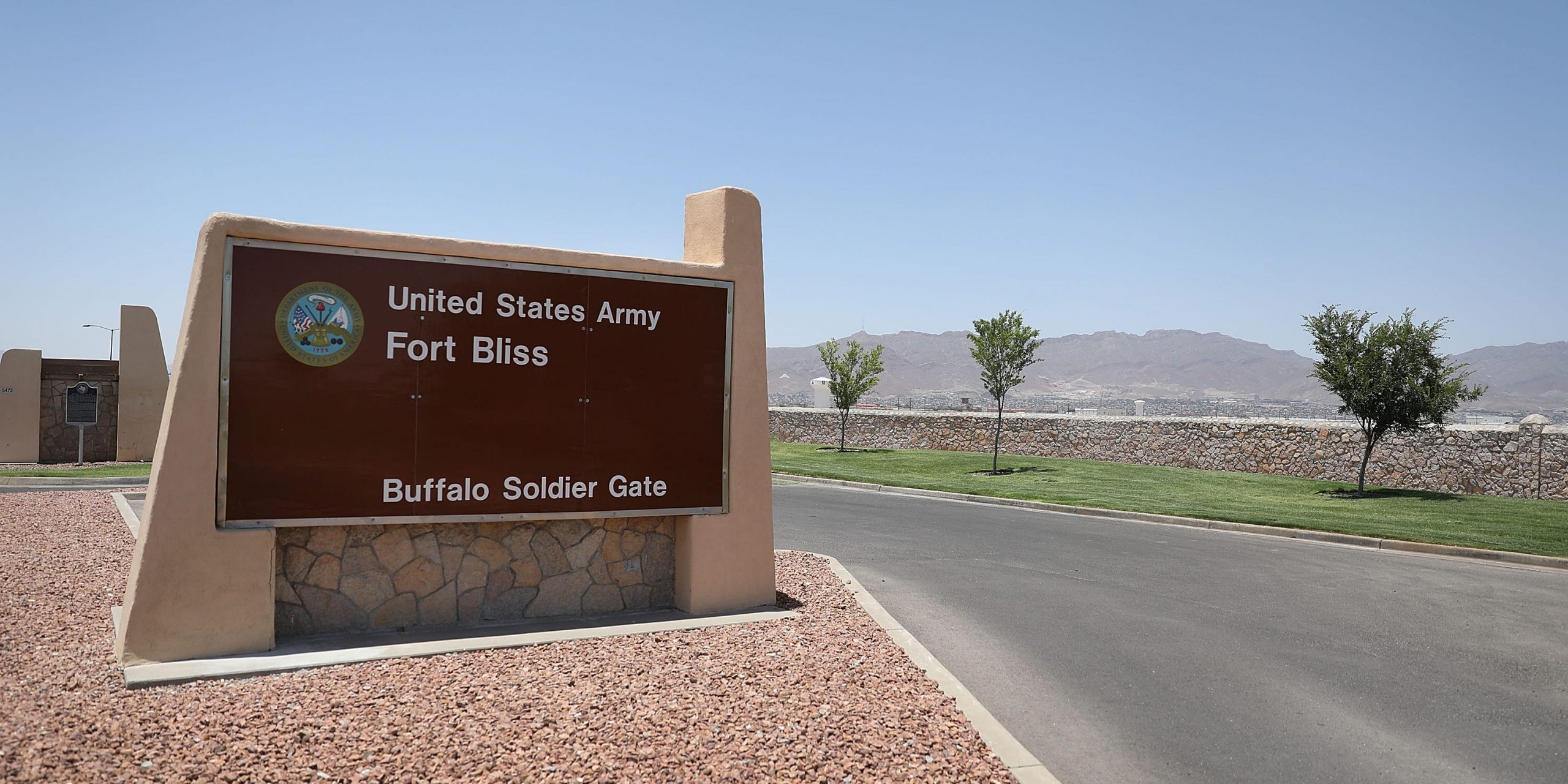 A "Fort Bliss" sign planted along the left side of a road in Texas.