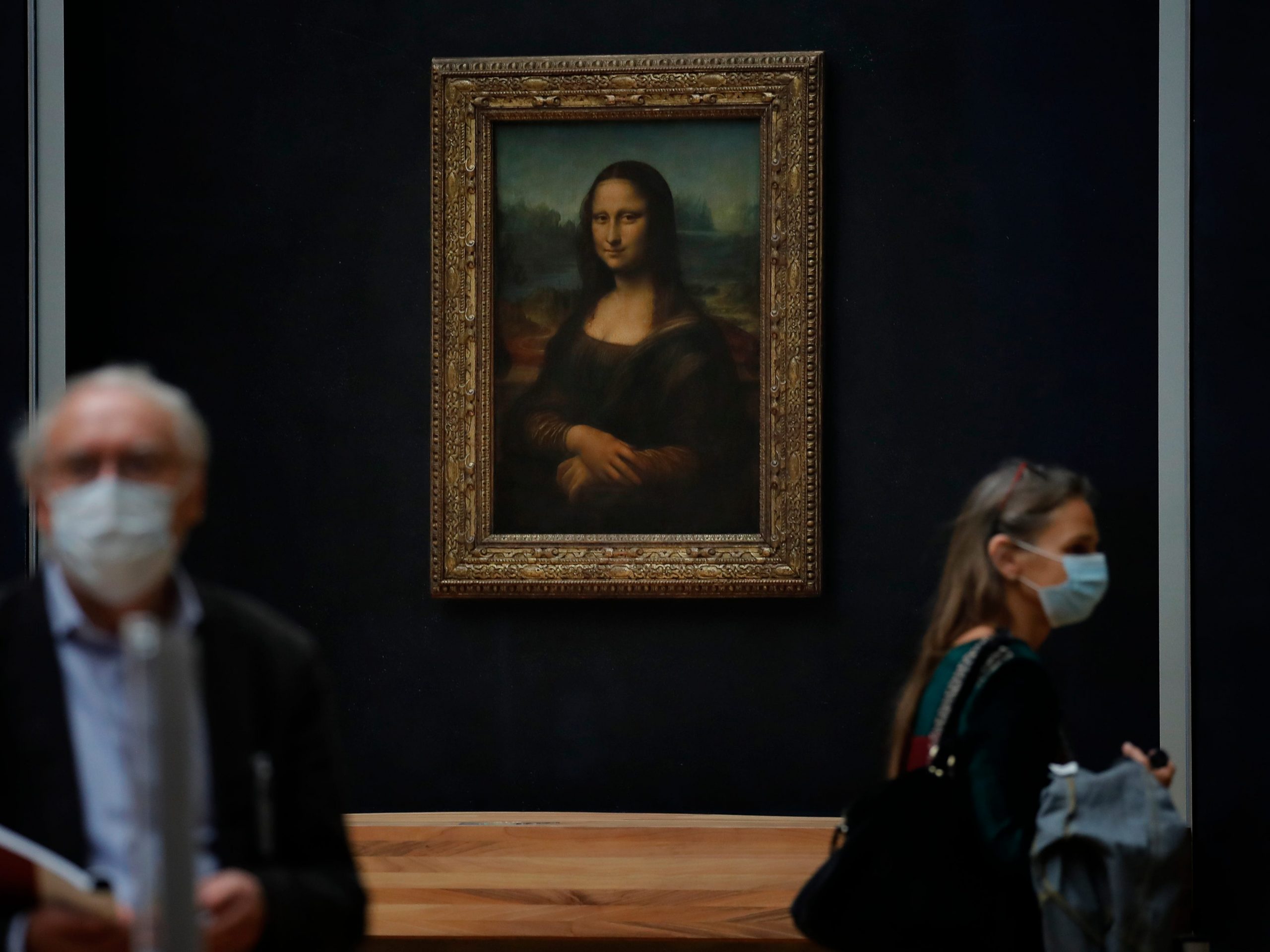 Journalists walk past Leonardo da Vinci's Mona Lisa during a visit of the Louvre museum ahead of its reopening next July 6, in Paris, Tuesday, June 23, 2020.  After four months of virus-imposed inactivity, the world's most visited museum is counting on the world’s most famous portrait, the “Mona Lisa” to help lure back visitors, when the Louvre reopens on July 6.(AP Photo/Christophe Ena)