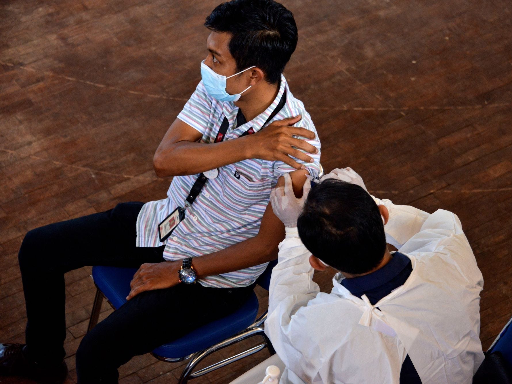 A man receives a dose of the Sinovac covid-19 coronavirus vaccine during a mass vaccination at a sports centre in Banda Aceh on June 19, 2021.