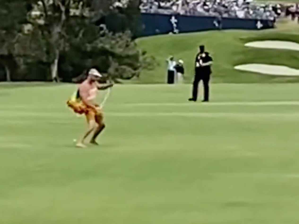 A fan storms the course at the 13th hole at the 2021 US Open.