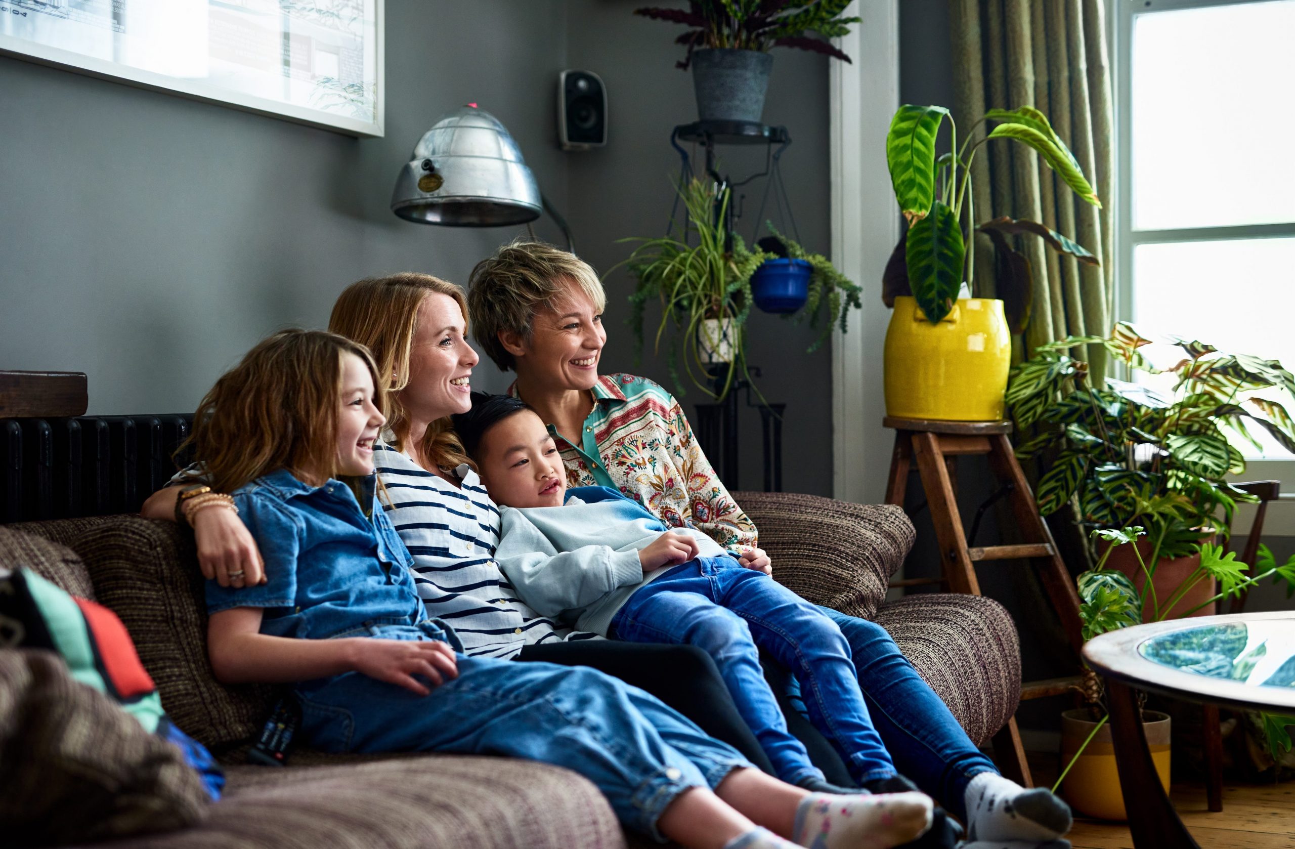 A married couple watches TV with their son and daughter