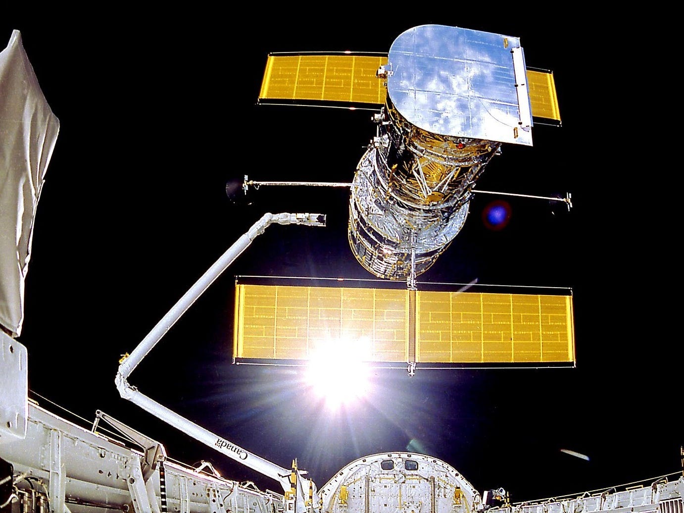 hubble space telesope deploys from space shuttle arm in earth orbit