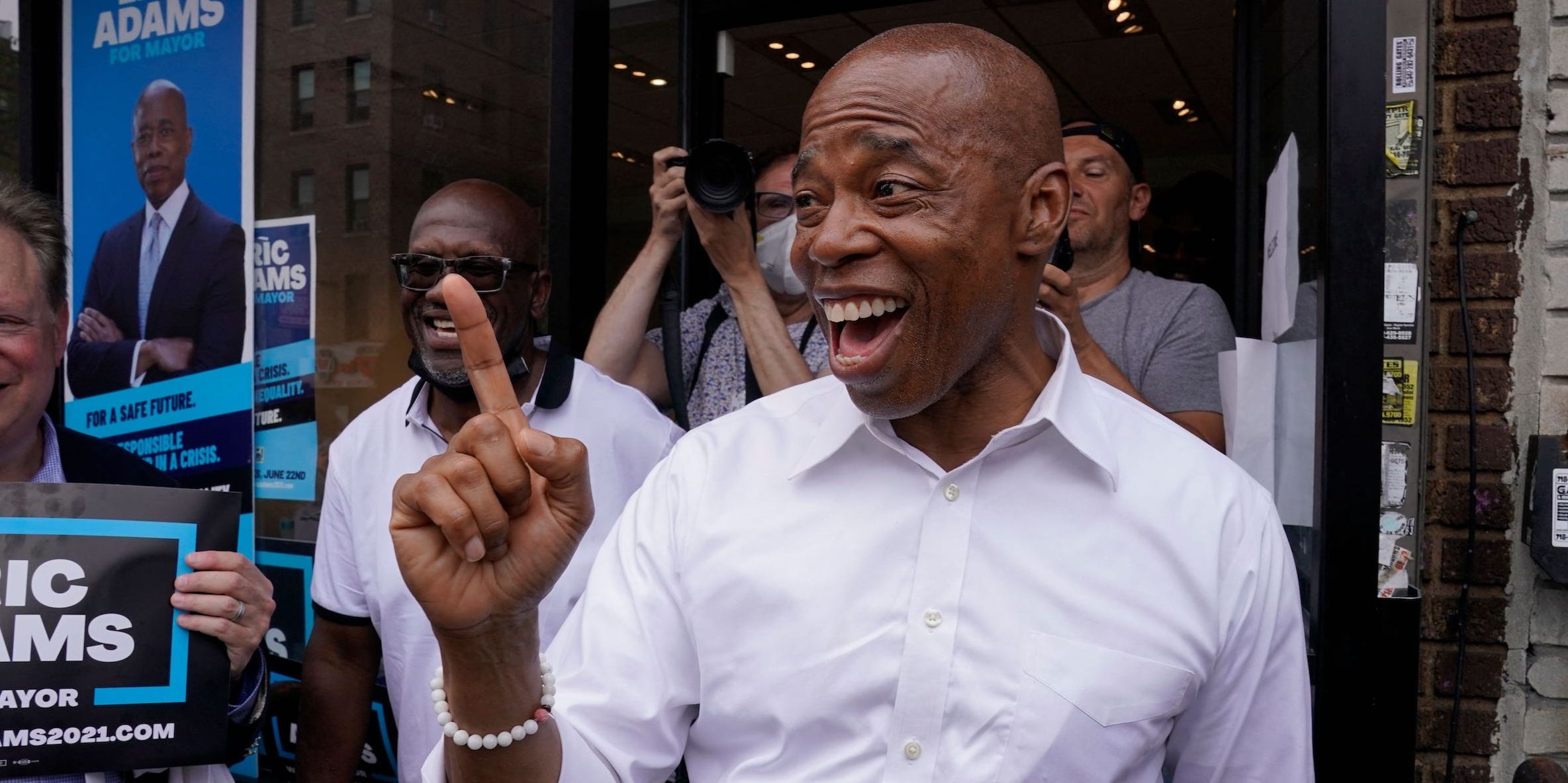 New York City mayoral candidate Eric Adams points his right finger in the air outside of his Brooklyn campaign office in Prospect Lefferts Gardens.