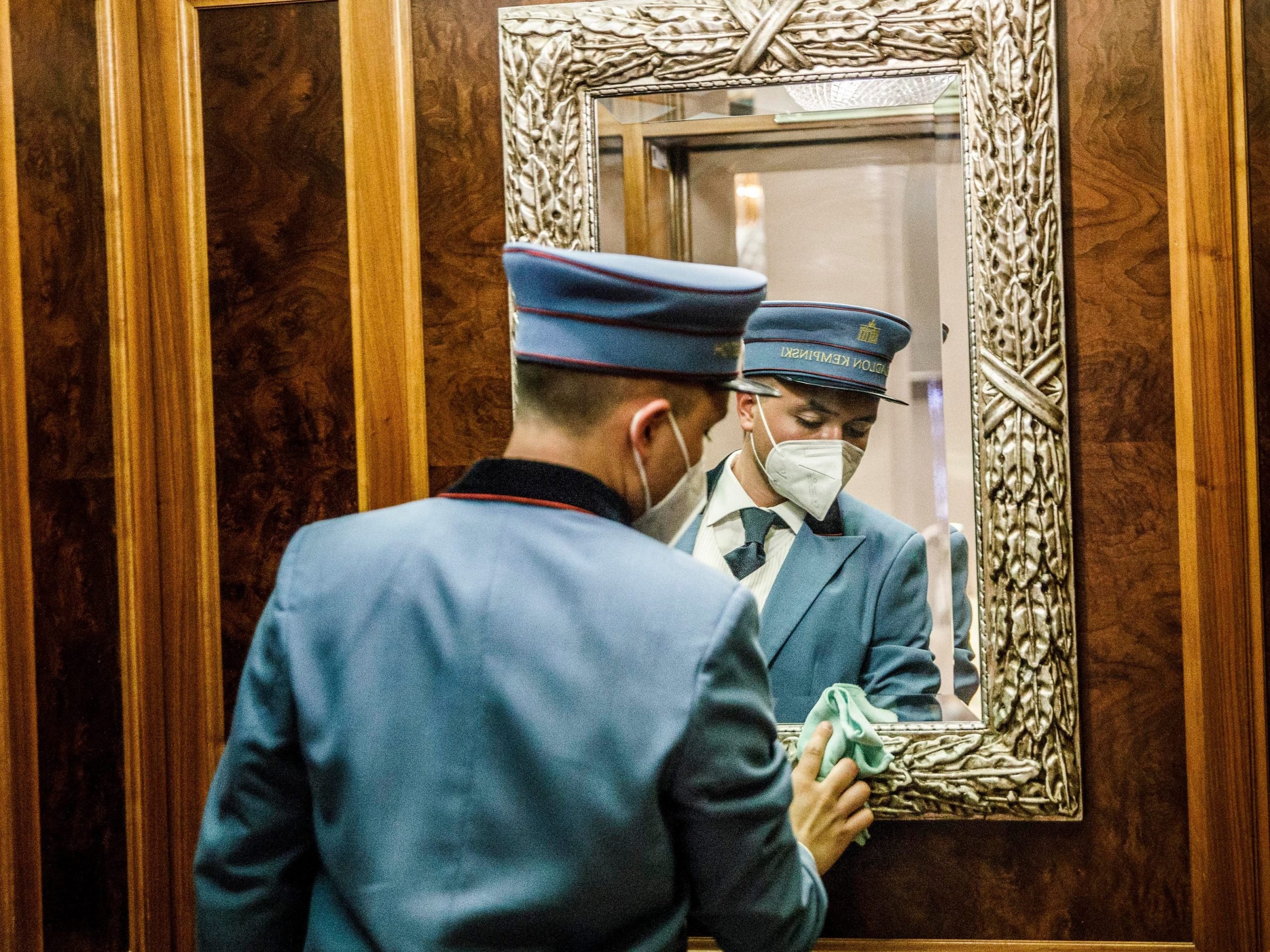 A bellboy cleans the mirror in the elevator during a press tour at the Hotel Adlon Kempinski at Pariser Platz.